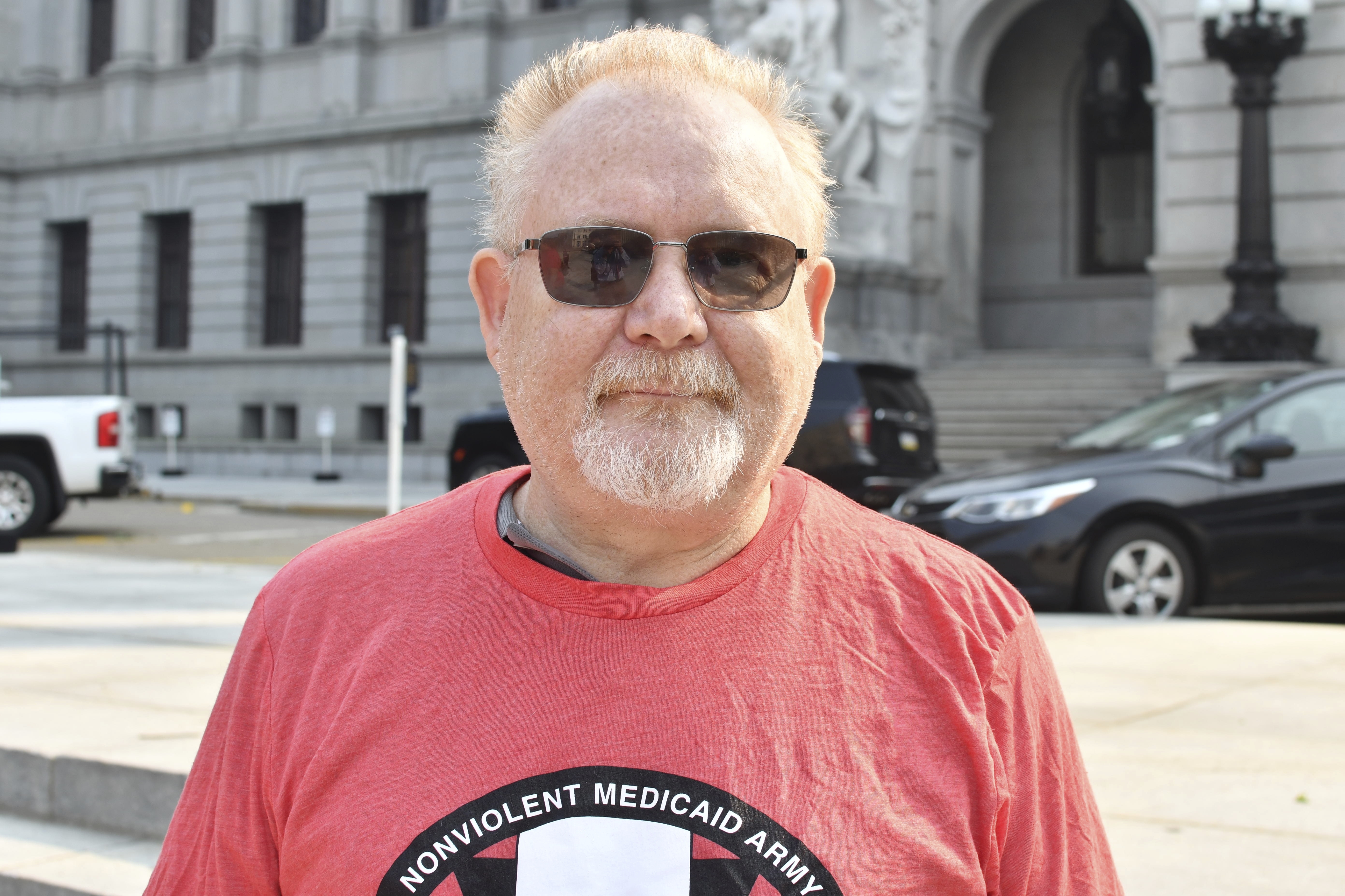 Gary Rush poses for a photo outside the Pennsylvania Capitol, June 7 in Harrisburg, Pa. Rush was demonstrating with the advocacy group Power to the People against the state removing people from Medicaid.