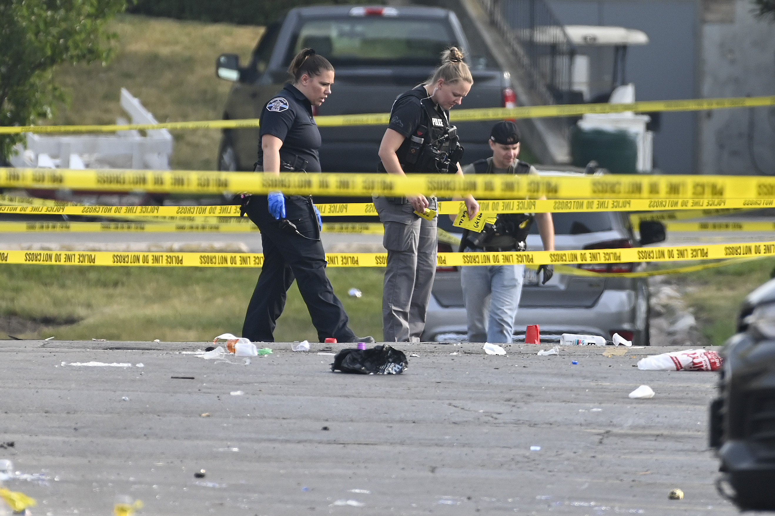 Investigators look over the scene of an overnight mass shooting at a strip mall in Willowbrook, Ill., Sunday. Mass shootings and violence across the U.S. over the weekend killed at least six people.