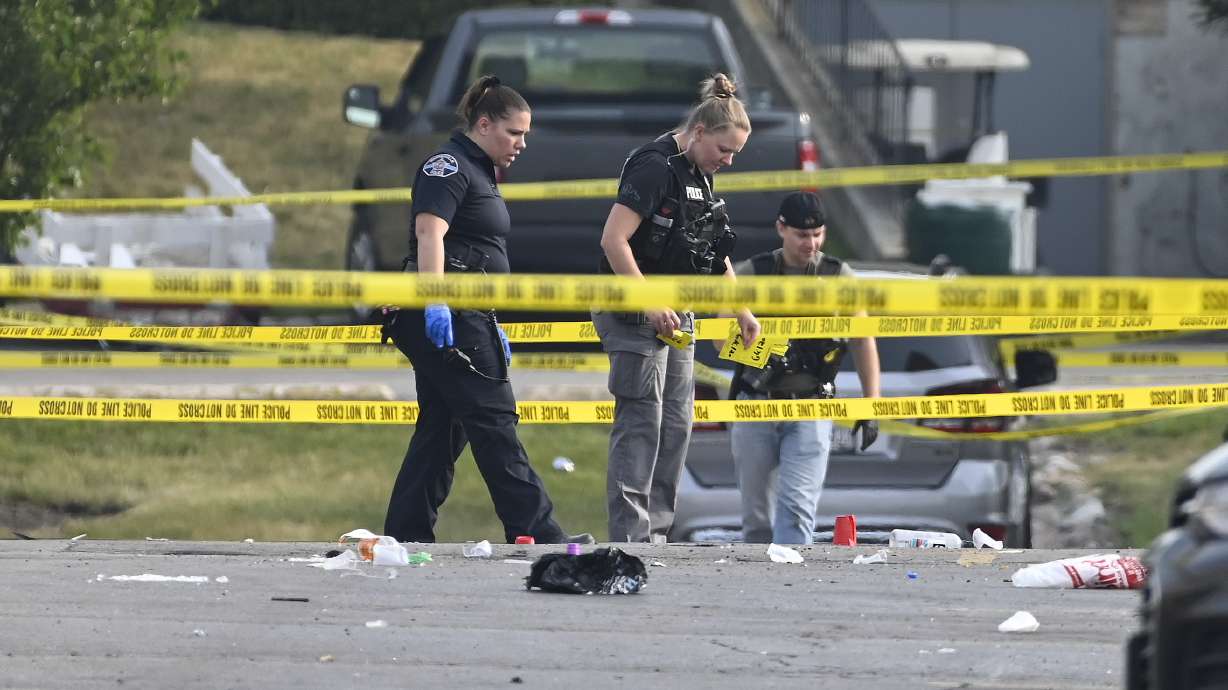 Investigators look over the scene of an overnight mass shooting at a strip mall in Willowbrook, Ill., Sunday. Mass shootings and violence across the U.S. over the weekend killed at least six people.