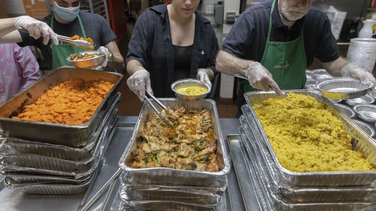 Nicholas Loud, left, Sophie Thurschwell, center, and Peter Woll prepare lunch boxes at Community Help in Park Slope, a soup kitchen and food pantry better known as CHiPS, on Friday in New York. Charitable giving in the United States declined in 2022.