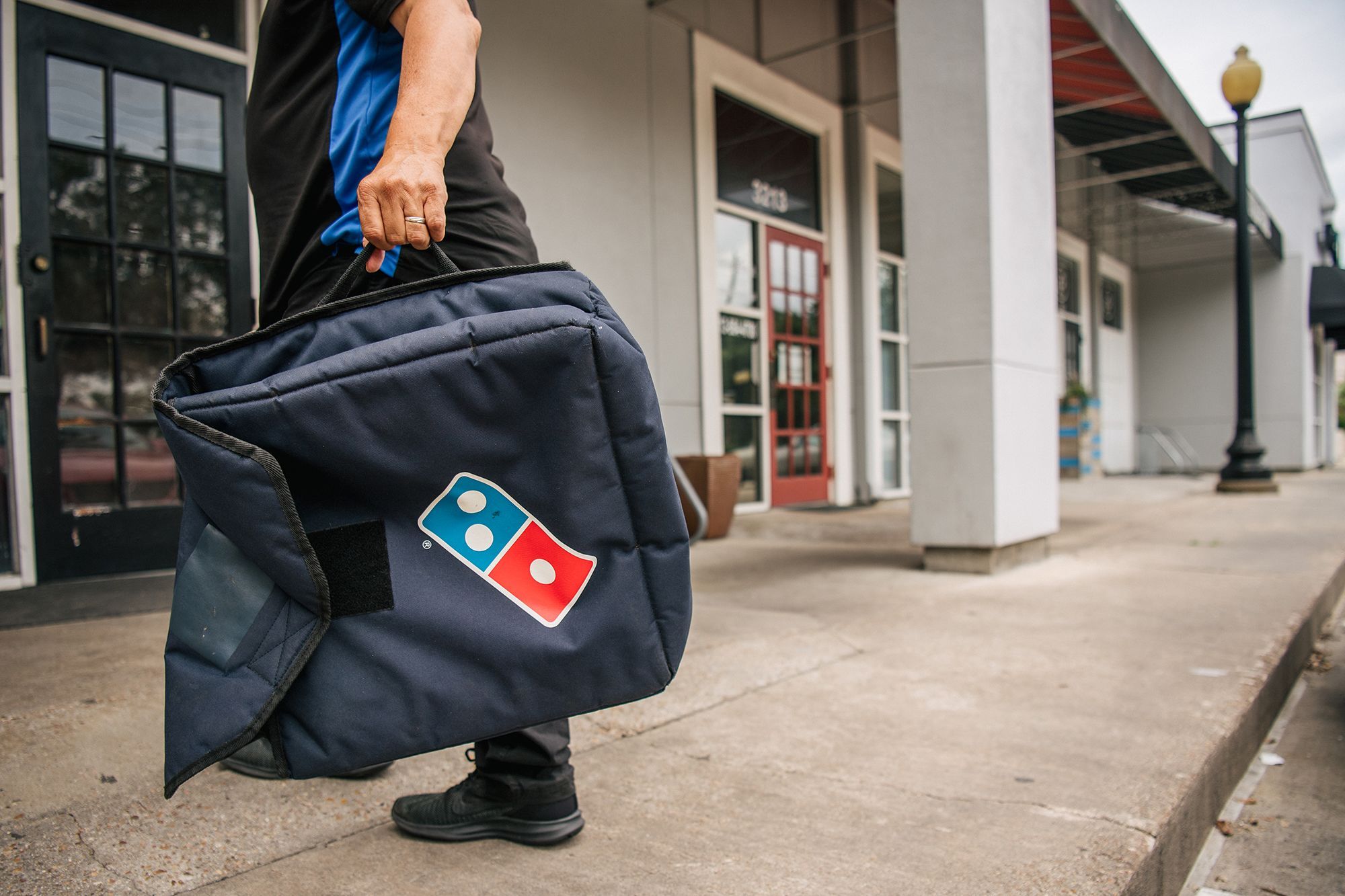 A Domino's Pizza employee returns from a delivery in 2021 in Houston, Texas. The pizza chain is launching "anywhere" delivery through its app.
