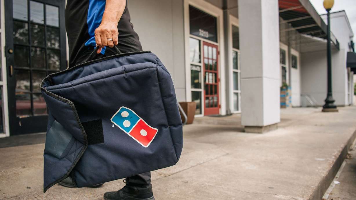 A Domino's Pizza employee returns from a delivery in 2021 in Houston, Texas. The pizza chain is launching "anywhere" delivery through its app.