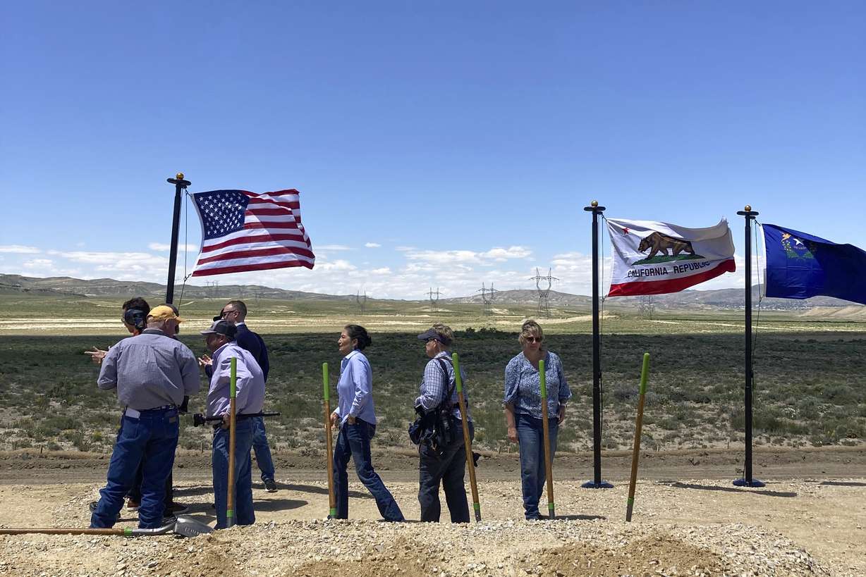 U.S. Interior Secretary Deb Haaland, center, takes part in a groundbreaking ceremony Tuesday for the TransWest Express transmission line south of Rawlins, Wyo. The transmission line will partly parallel the existing PacifiCorp Gateway West transmission system, seen in the background, moving electricity from a planned 600-turbine wind farm to California.