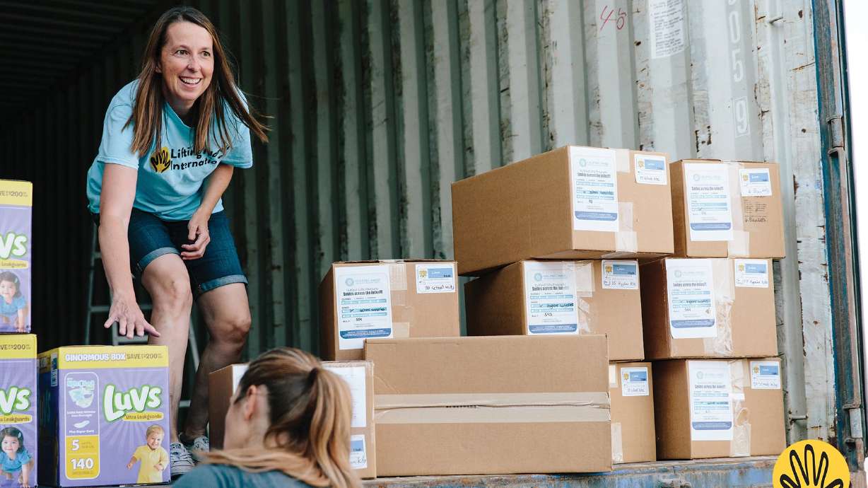 Traci Parson, Lifting Hands International's director of Utah operations, helps load a shipping container with items collected in Utah to be sent to Syrian refugees in Jordan.