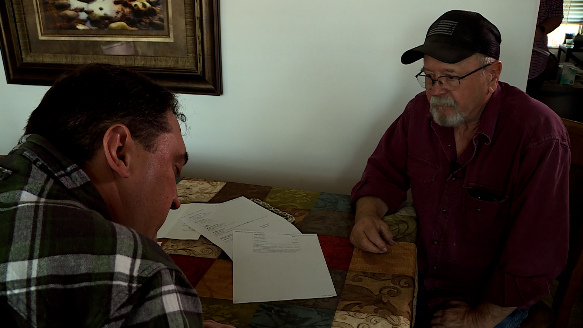 Dale Heiser, right, reviews his travel insurance paperwork with KSL-TV’s Matt Gephardt after his claim for a flight he canceled was denied.