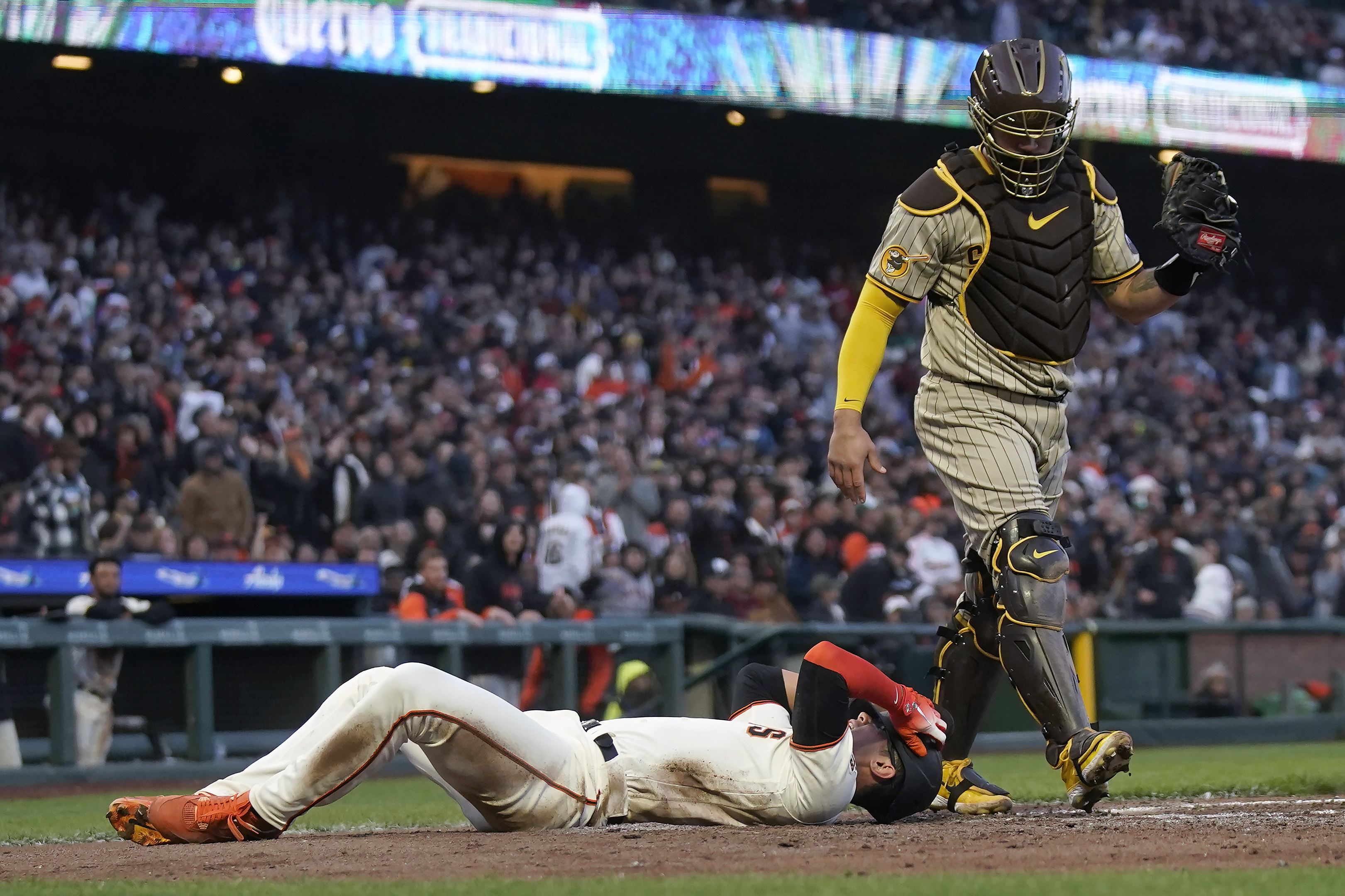 San Francisco Giants' Blake Sabol, bottom, reacts after scoring against San Diego Padres catcher Gary Sanchez during the fifth inning of a baseball game in San Francisco, Wednesday, June 21, 2023. Sabol was initially called out but was ruled safe after the Giants challenged.