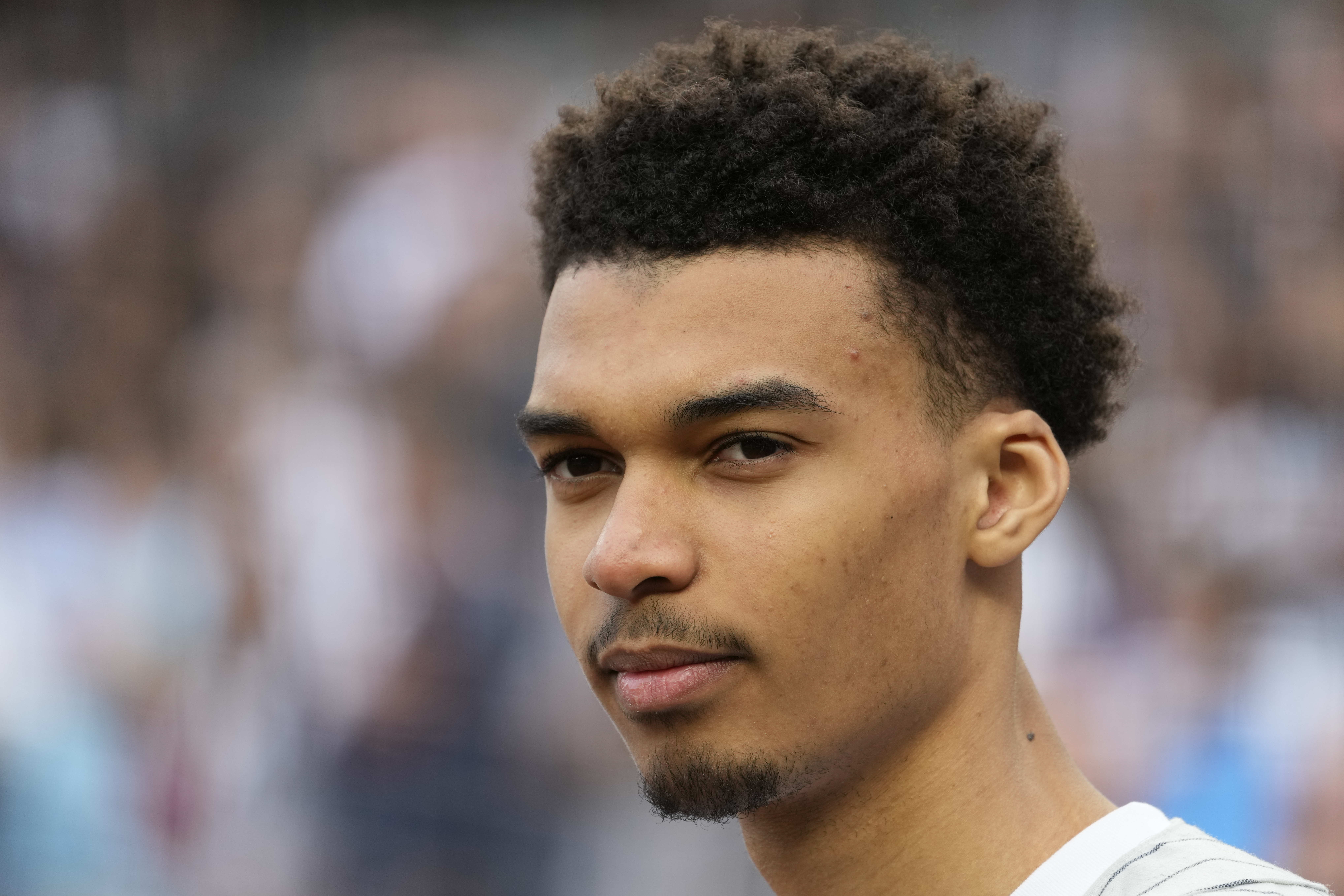 Victor Wembanyama, a projected first-round NBA draft pick, stands on the warning track after throwing the ceremonial first pitch before a baseball game between the New York Yankees and the Seattle Mariners, Tuesday, June 20, 2023, in New York. 