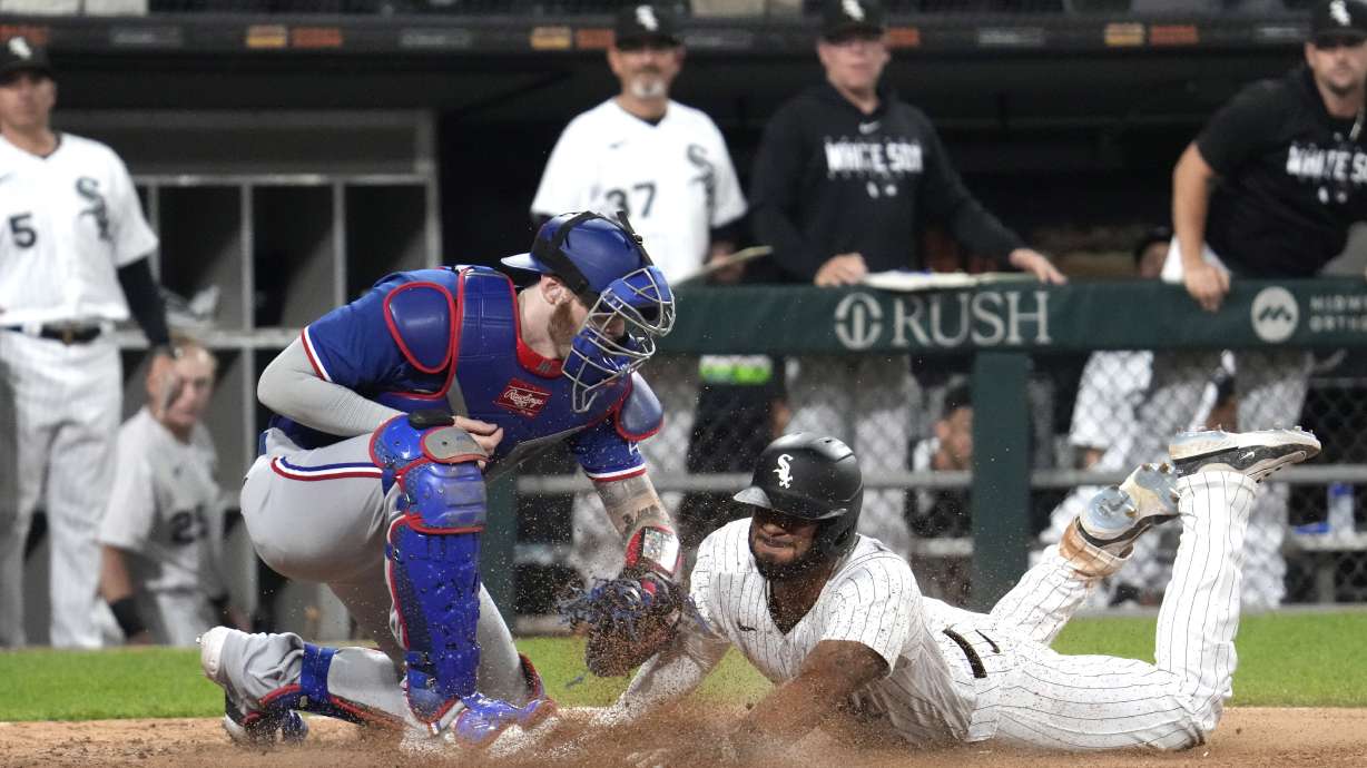 Chicago White Sox's Elvis Andrus, right, scores against Texas Rangers catcher Jonah Heim during the eighth inning of a baseball game in Chicago, Tuesday, June 20, 2023. The White Sox won 7-6.
