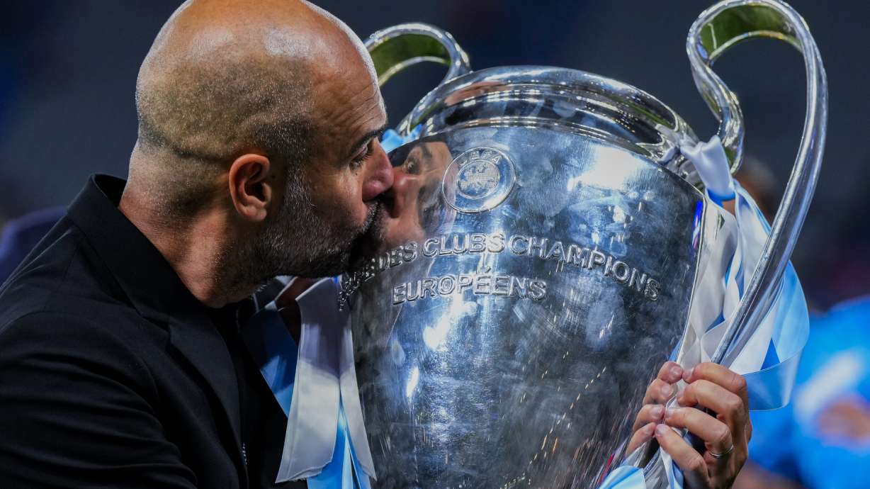 Manchester City's head coach Pep Guardiola kisses the trophy after winning the Champions League final soccer match between Manchester City and Inter Milan at the Ataturk Olympic Stadium in Istanbul, Turkey, Sunday, June 11, 2023. Manchester City won 1-0.