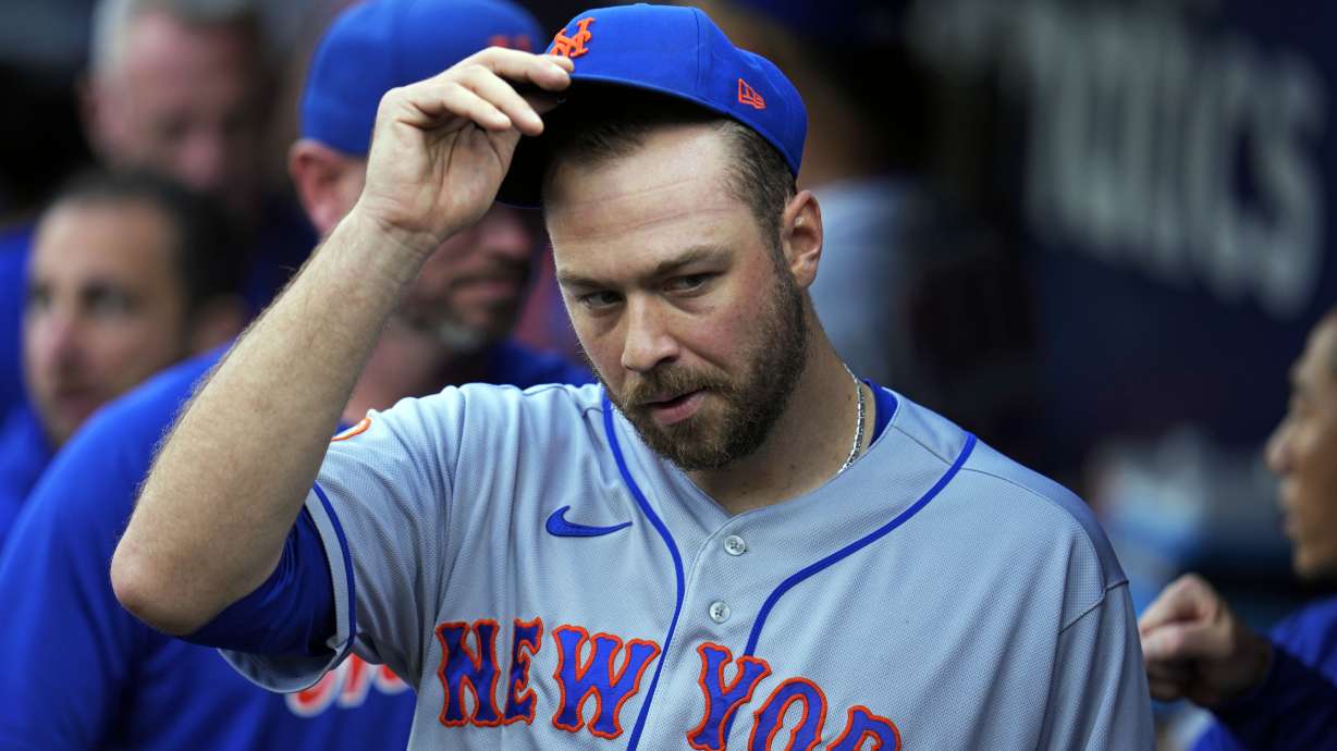 New York Mets starting pitcher Tylor Megill takes off his cap in the dugout before a baseball game against the Pittsburgh Pirates in Pittsburgh, Friday, June 9, 2023.