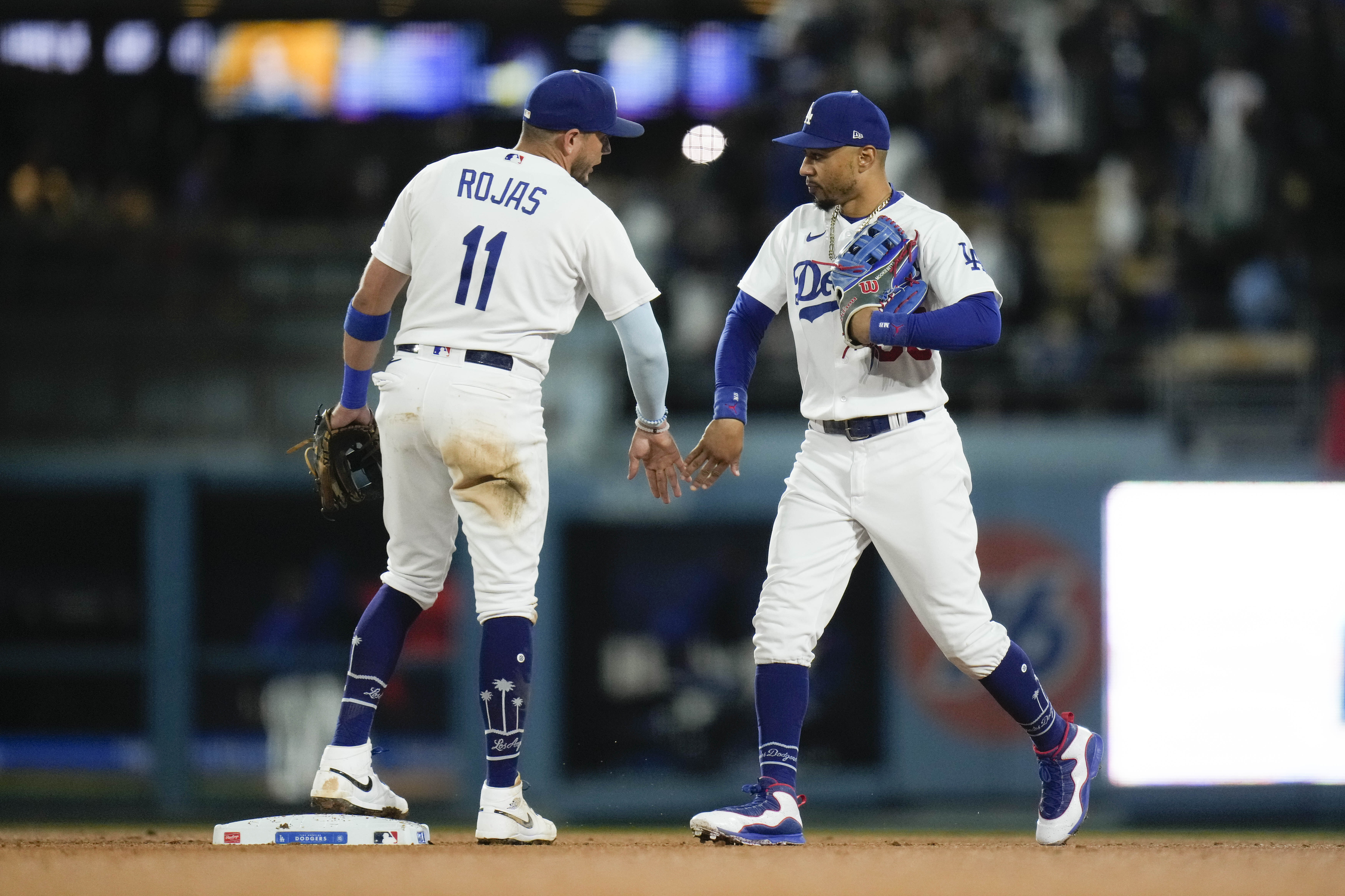 Los Angeles Dodgers' Miguel Rojas (11) and Mookie Betts celebrate the team's win against the Houston Astros in a baseball game Friday, June 23, 2023, in Los Angeles. 