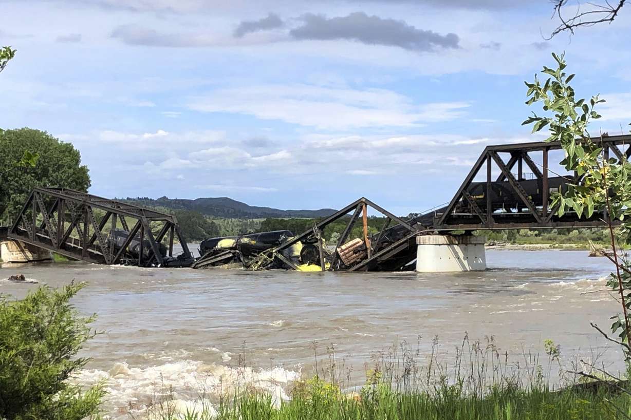 Several train cars are immersed in the Yellowstone River after a bridge collapse near Columbus, Montana, on Saturday. The bridge collapsed overnight, causing a train that was traveling over it to plunge into the water below.