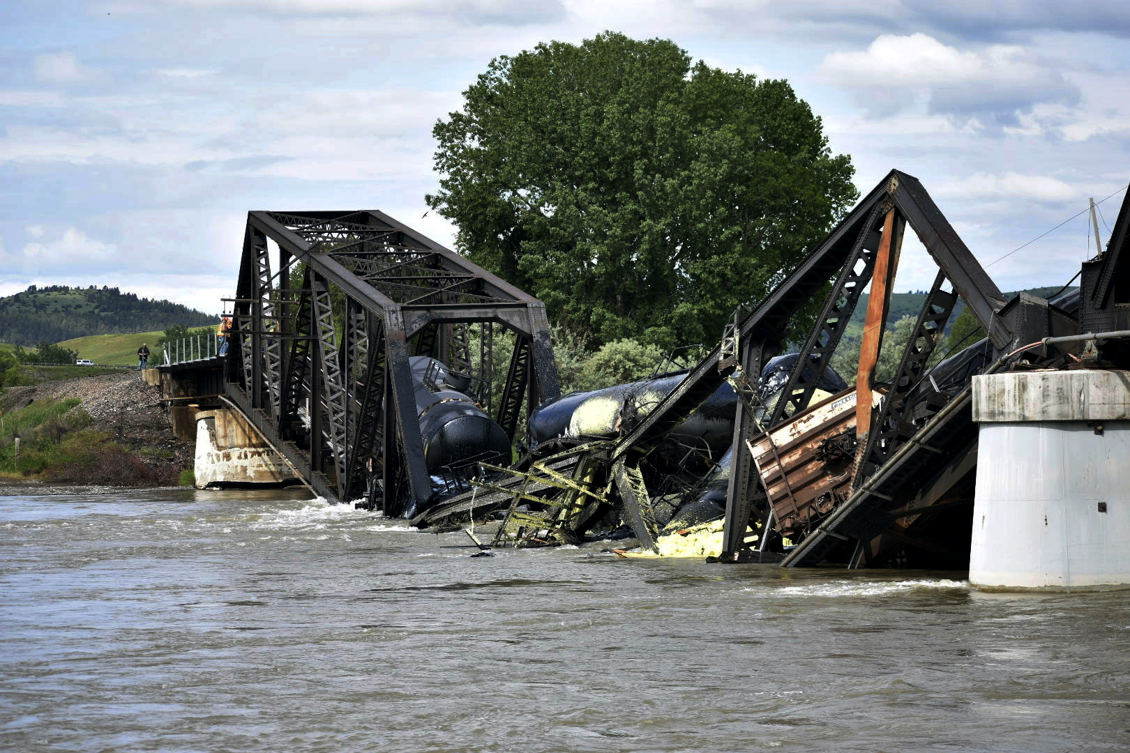 Several train cars are immersed in the Yellowstone River after a bridge collapse near Columbus, Montana, on Saturday. The bridge collapsed overnight, causing a train that was traveling over it to plunge into the water below.