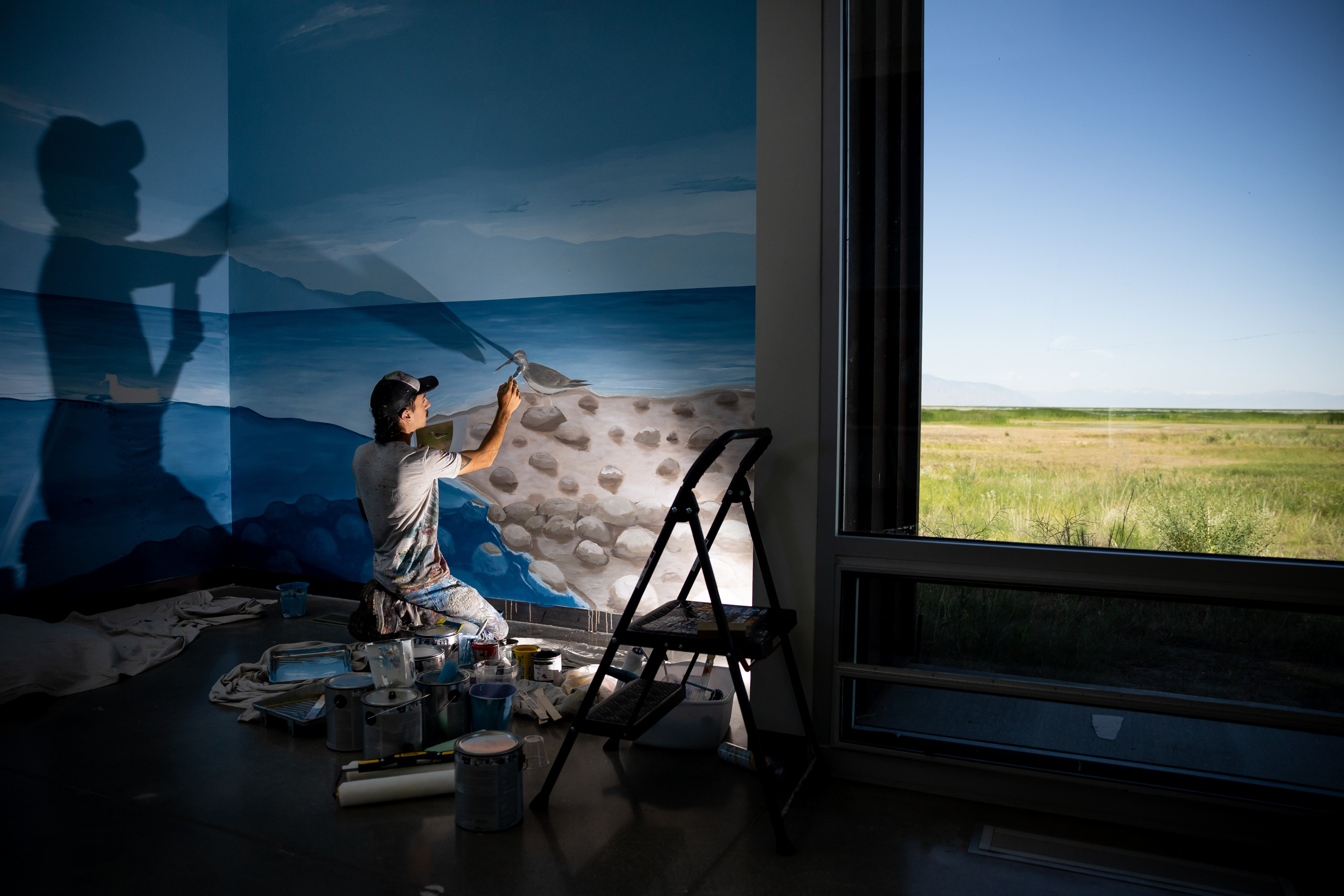 Argentinian artist Franco Cervata Cozza, who also goes by the artist name Vato, paints a mural at the George S. and Dolores Doré Eccles Wildlife Education Center in Farmington on Saturday.