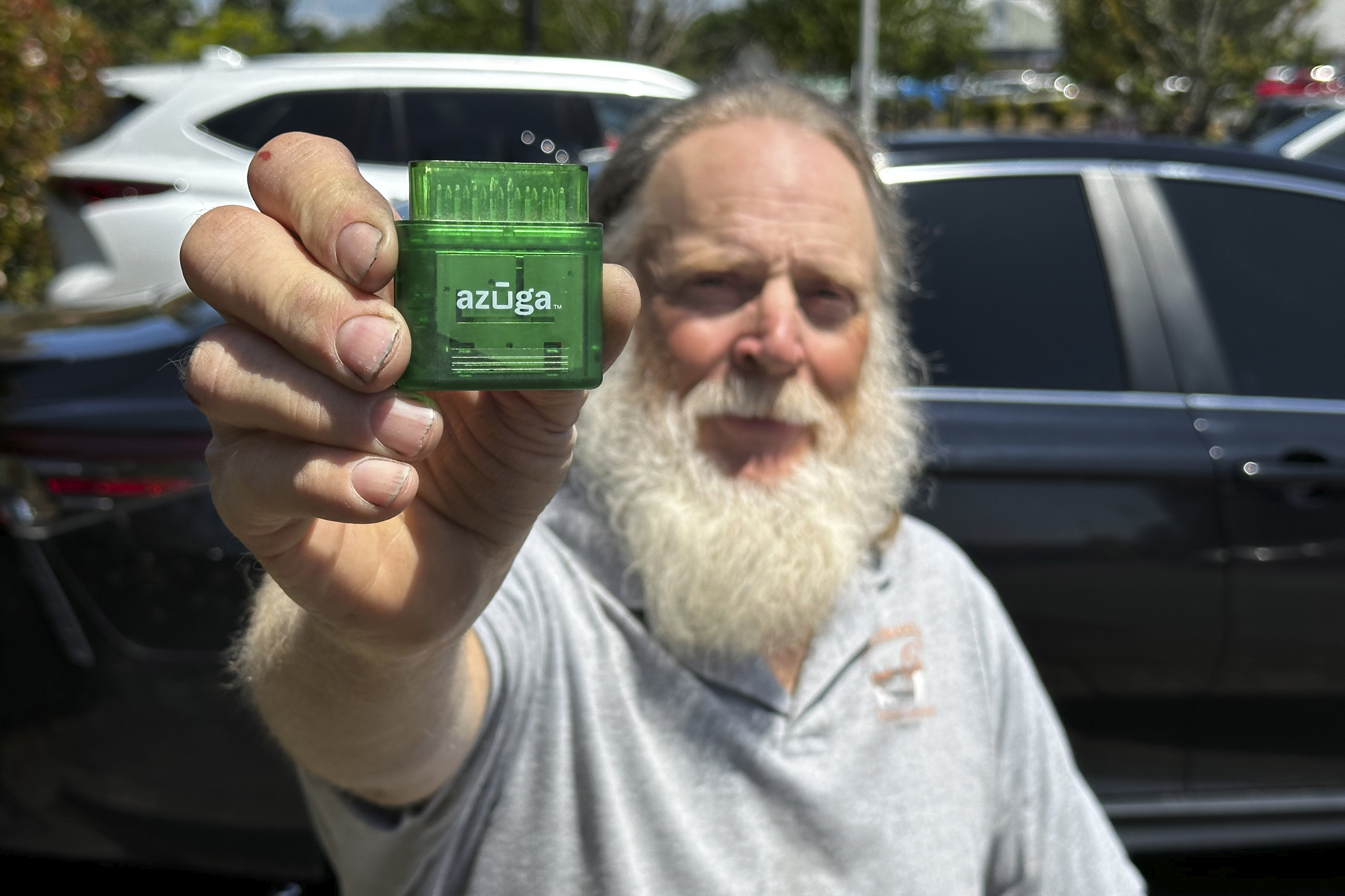 Evan Burroughs, who touts an Oregon pilot program that charges motorists by the distance, displays a tracking device the program uses, in Salem, Oregon, on June 21. U.S. states are experimenting with road usage charging programs.