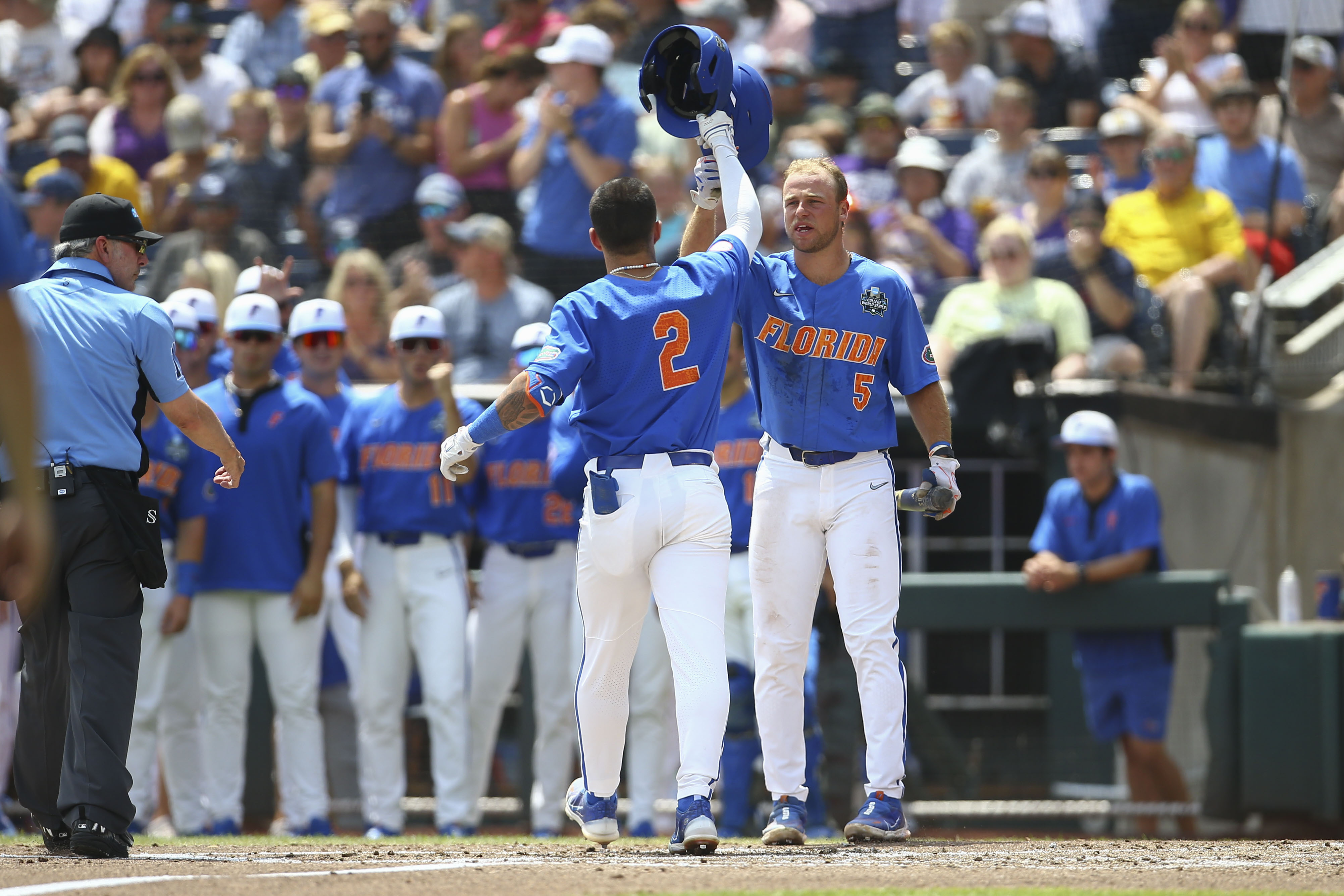 Florida outfielder Ty Evans (2) is greeted at the plate by Ben Nippolt (5) after his solo home run during the second inning of Game 2 of the NCAA College World Series baseball finals against LSU in Omaha, Neb., Sunday, June 25, 2023. 