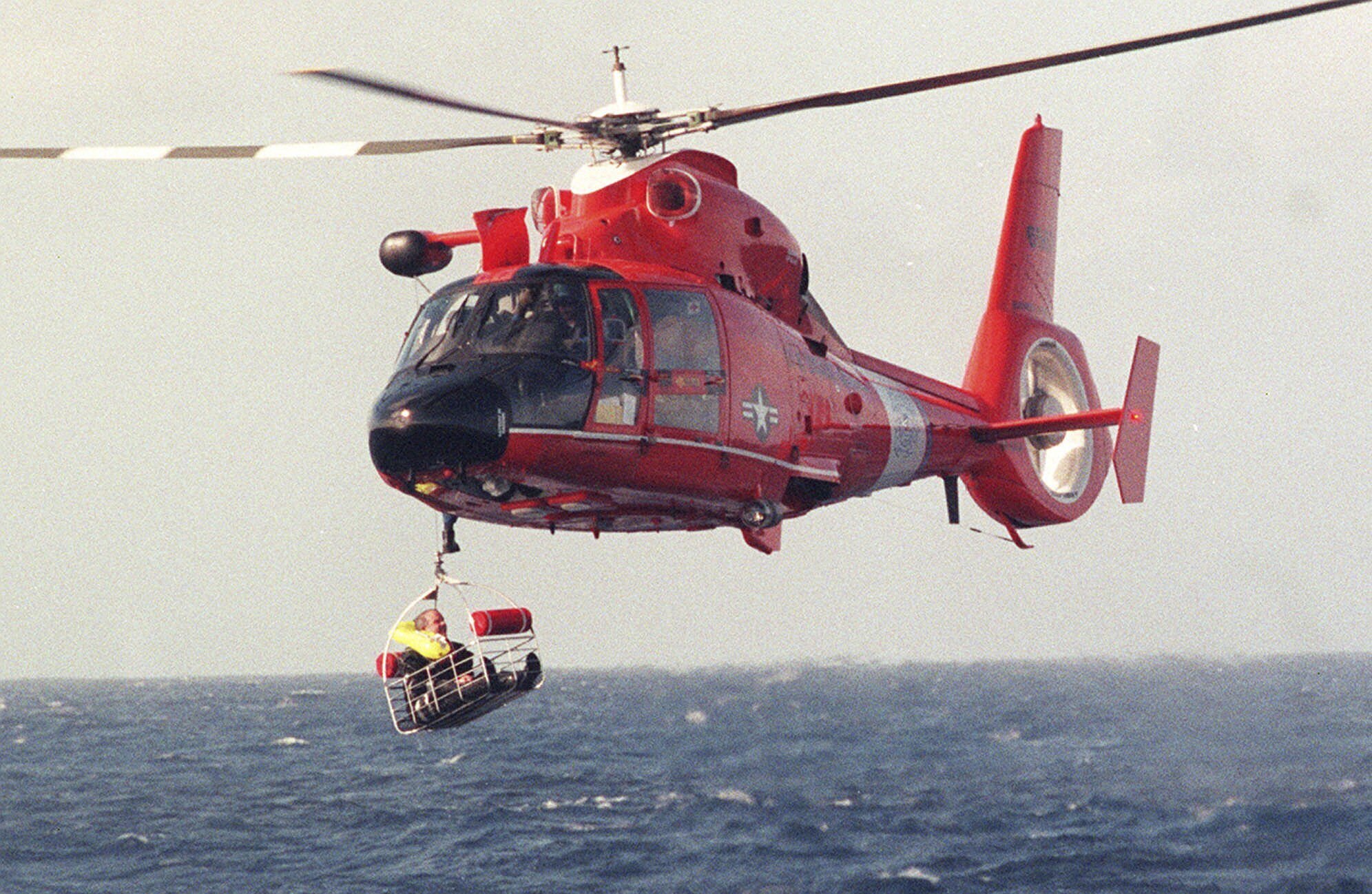 FILE - Balloonist Steve Fossett is retrieved by a U.S. Coast Guard helicopter from waters 10-15 miles north of the island of Oahu in the Hawaiian Islands, Dec. 25, 1998, after abandoning his quest along with Per Lindstrand, of Sweden, and British mogul Richard Branson, who were attempting to make the first nonstop round-the-world flight in a balloon. The massive hunt for the Titan submersible that imploded deep in the North Atlantic has refocused attention on whether wealthy risktakers should pay for emergency search and rescue efforts. 
