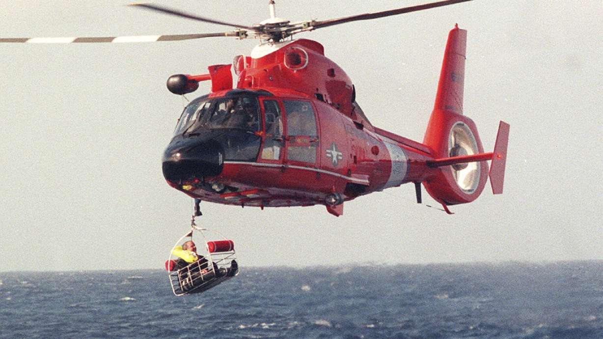 FILE - Balloonist Steve Fossett is retrieved by a U.S. Coast Guard helicopter from waters 10-15 miles north of the island of Oahu in the Hawaiian Islands, Dec. 25, 1998, after abandoning his quest along with Per Lindstrand, of Sweden, and British mogul Richard Branson, who were attempting to make the first nonstop round-the-world flight in a balloon. The massive hunt for the Titan submersible that imploded deep in the North Atlantic has refocused attention on whether wealthy risktakers should pay for emergency search and rescue efforts.