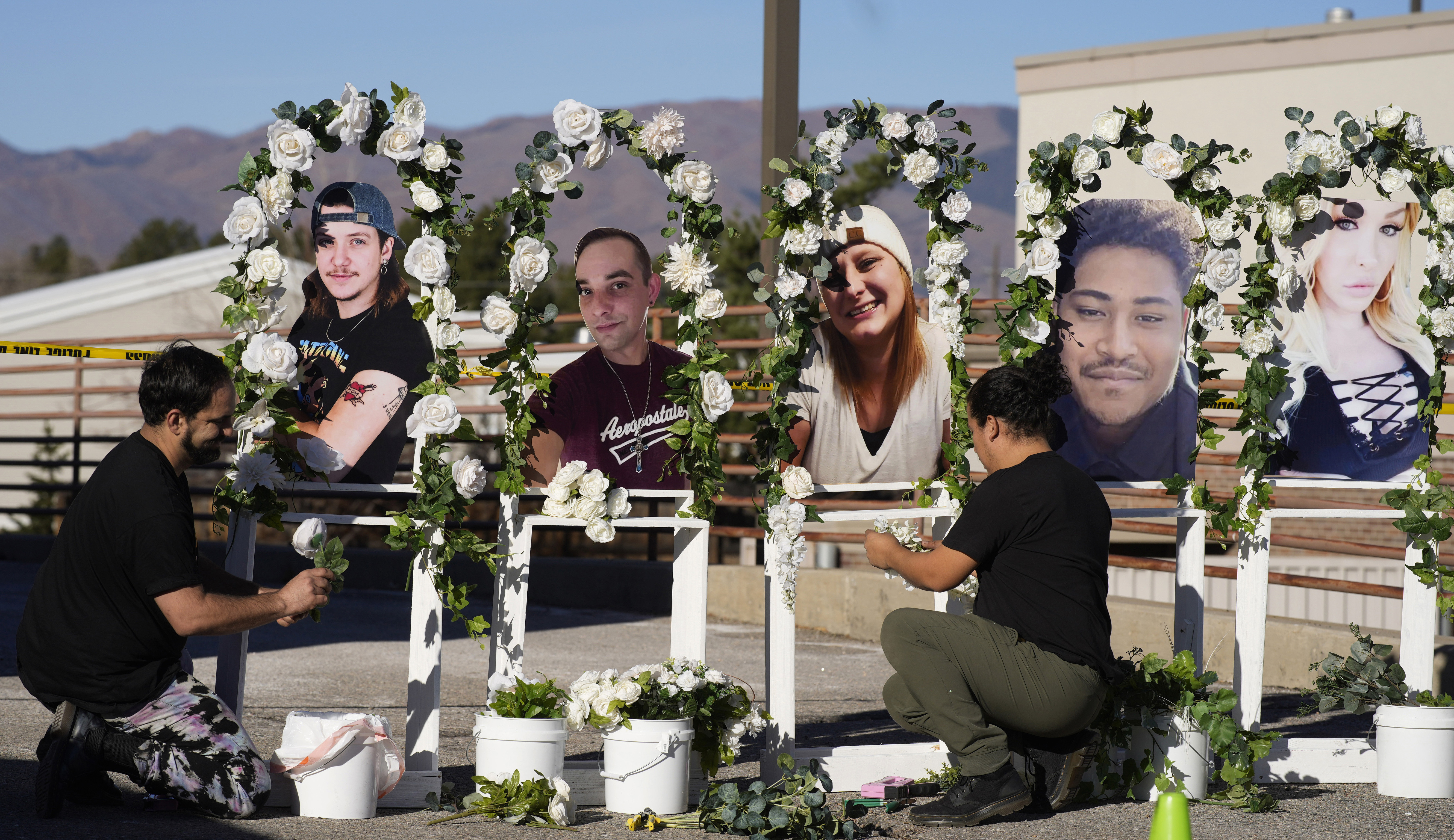 Noah Reich, left, and David Maldonado, the Los Angeles co-founders of Classroom of Compassion, set up a memorial near Club Q in Colorado Springs, Colo., on Nov. 22, 2022, with photos of the five victims of a mass shooting at the gay nightclub. 