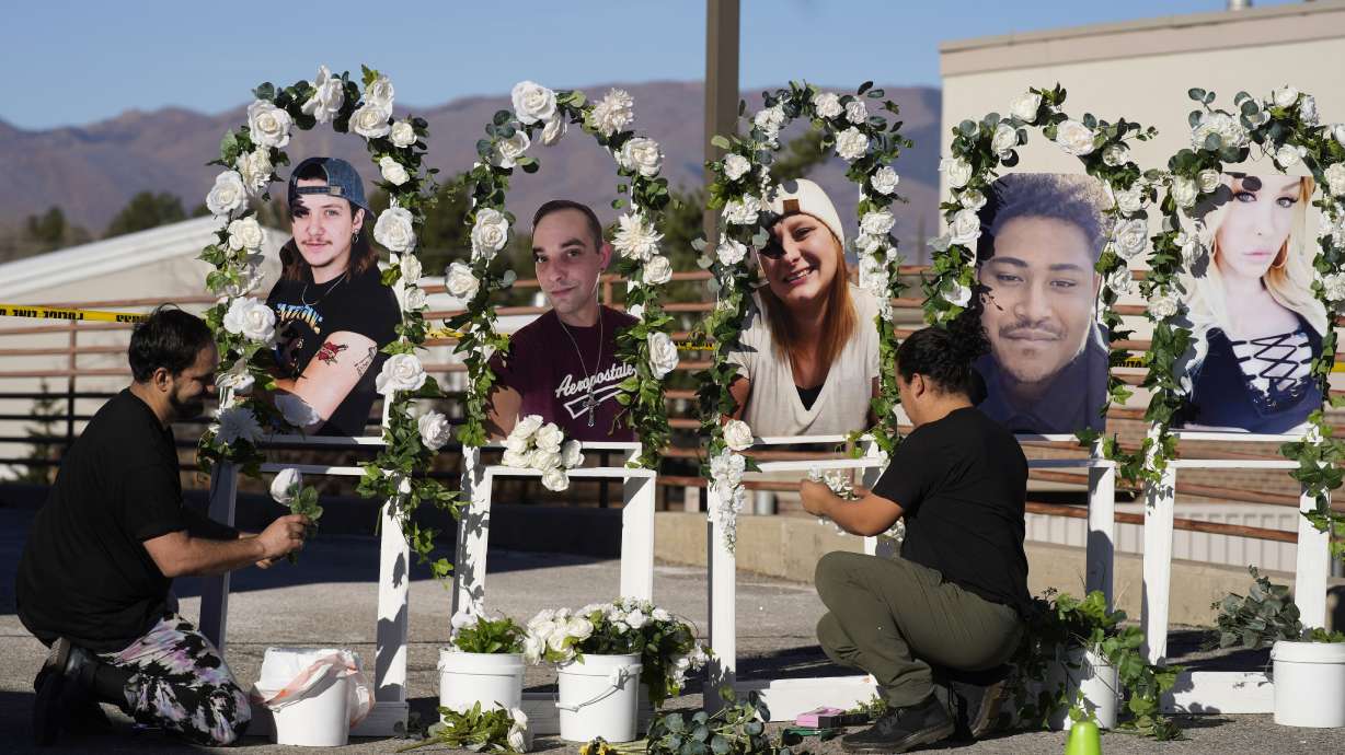 Noah Reich, left, and David Maldonado, the Los Angeles co-founders of Classroom of Compassion, set up a memorial near Club Q in Colorado Springs, Colo., on Nov. 22, 2022, with photos of the five victims of a mass shooting at the gay nightclub.