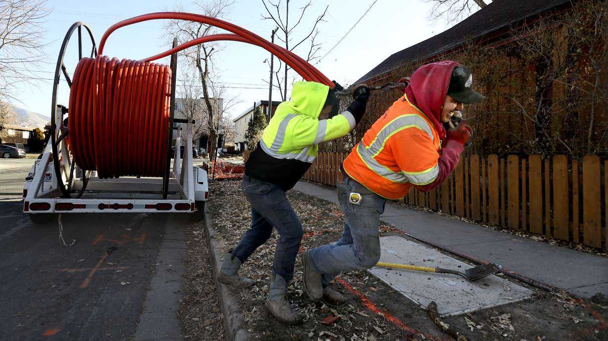 Jose Reyes and Aval G., of LightLink Communications, install cable in Salt Lake City on Dec. 3, 2020. Utah is set to receive $317.4 million to expand access to high-speed internet.