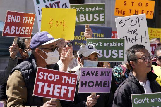 People take part in a rally to end the eviction moratorium outside City Hall in Oakland, Calif., April 11. Some landlords have gone without rental income for more than three years after Oakland approved an eviction moratorium in March 2020.