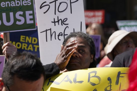 Michelle Hailey reacts while listening to speakers during a rally to end the eviction moratorium outside City Hall in Oakland, Calif.,  April 11. Some landlords have gone without rental income for more than three years after Oakland approved an eviction moratorium in March 2020.