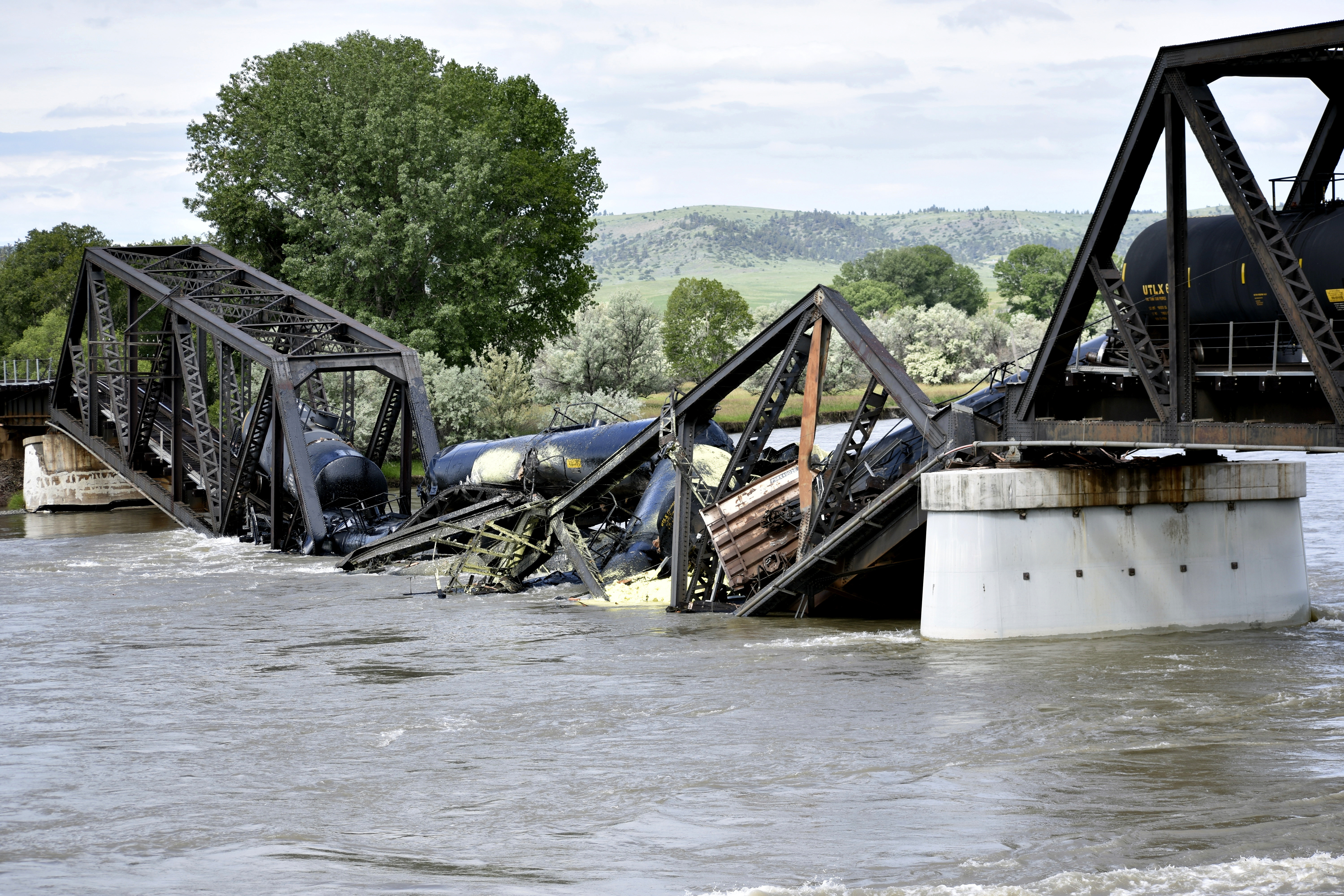 Several train cars are immersed in the Yellowstone River after a bridge collapse near Columbus, Montana, on Saturday. The bridge collapsed overnight, causing a train that was traveling over it to plunge into the water below. 
