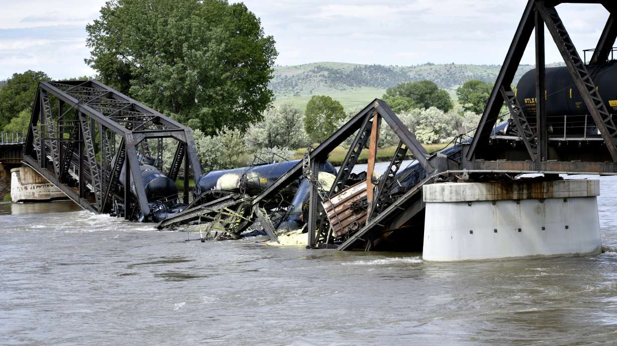 Several train cars are immersed in the Yellowstone River after a bridge collapse near Columbus, Montana, on Saturday. The bridge collapsed overnight, causing a train that was traveling over it to plunge into the water below.
