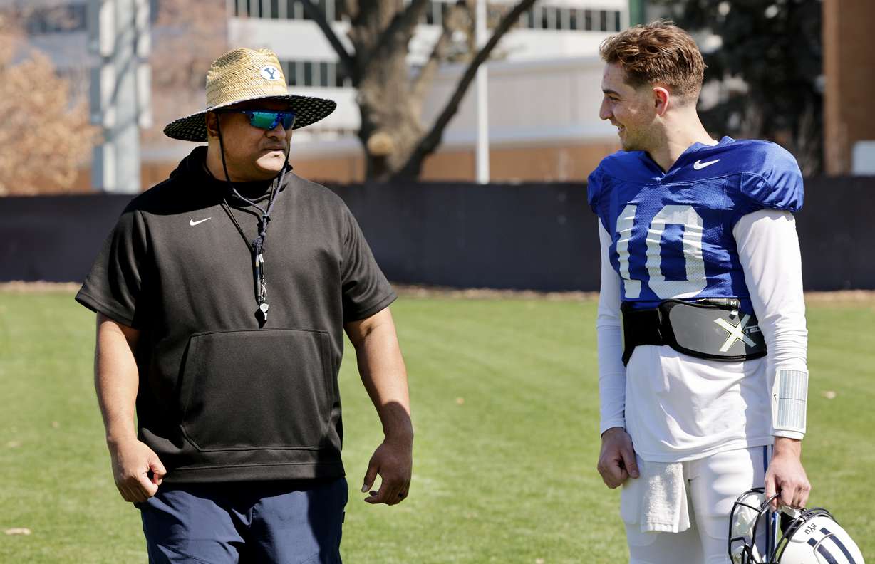 BYU head coach Kalani Sitake talks with quarterback Kedon Slovis after the Cougars' football team practiced in Provo on Friday, March 17, 2023.