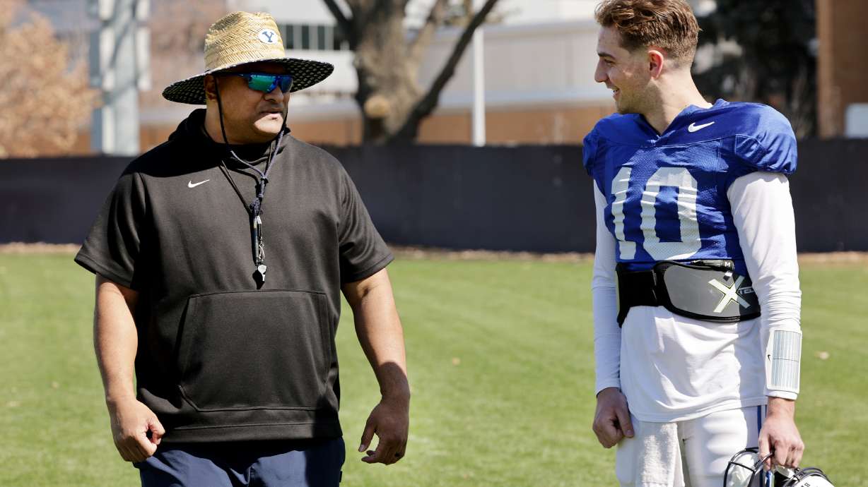 BYU head coach Kalani Sitake talks with quarterback Kedon Slovis after the Cougars' football team practiced in Provo on Friday, March 17, 2023.