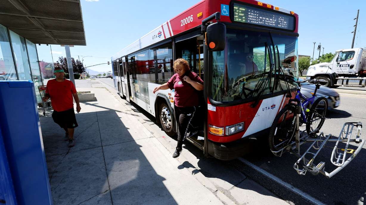People get on and off a Utah Transit Authority bus near Redwood Road and 3500 South in West Valley City on Monday. Some of UTA's fleet will be transitioned from diesel to compressed natural gas.