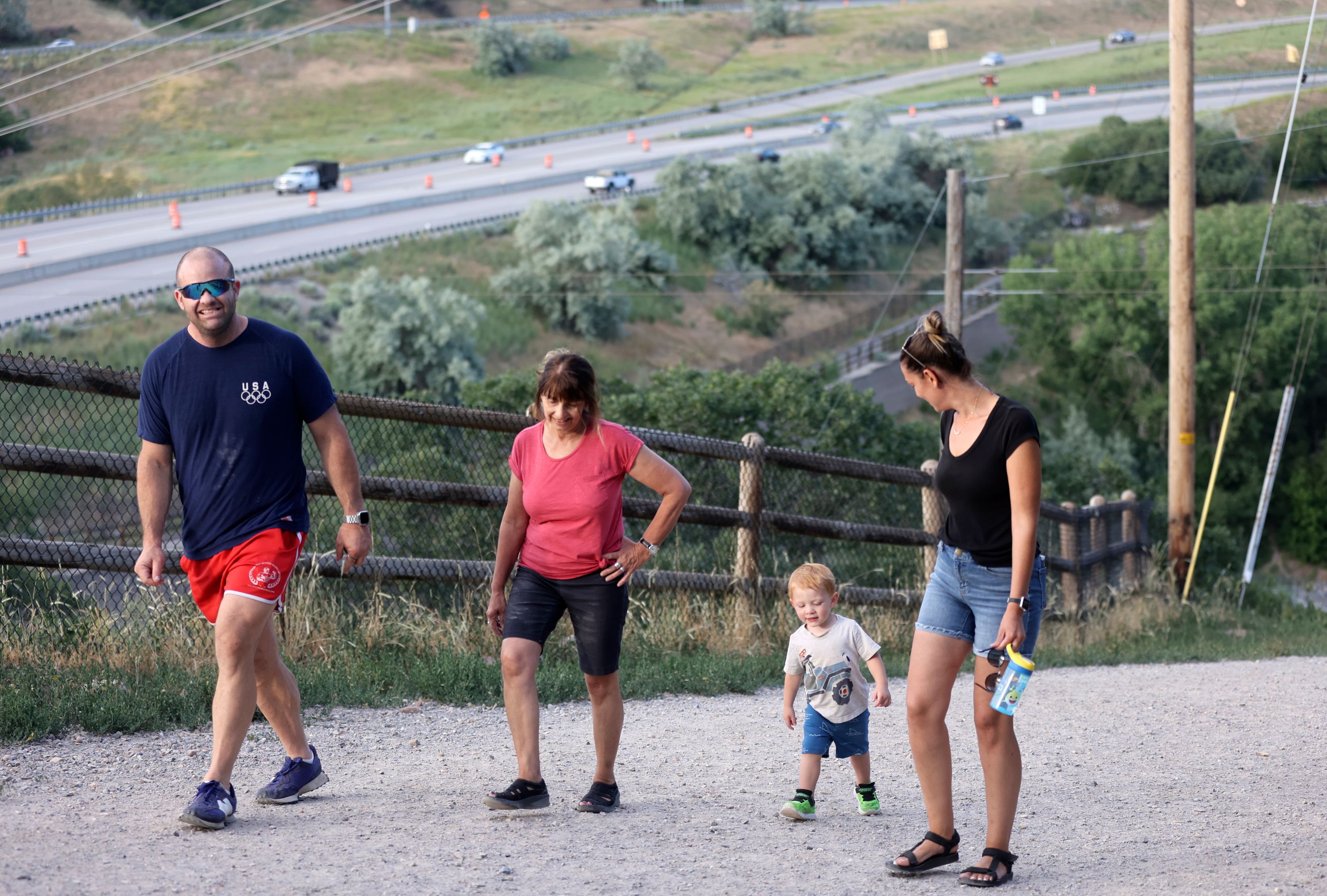 Casey Moore, Julie Newman, AJ Moore and Juliet Moore walk in Tanner Park, next to I-80 and I-215 in Salt Lake City on Monday.