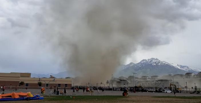 An unusually sized dust devil terrorizes a Utah school playground June 1.