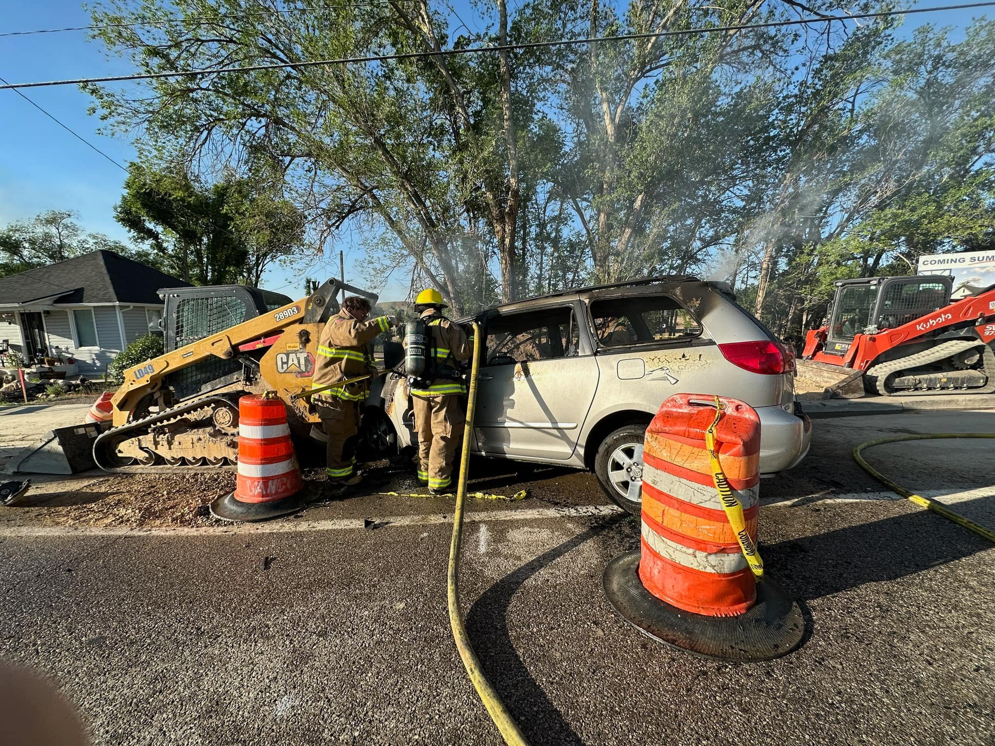 Firefighters extinguish a car fire after bystanders rescued the car’s passenger in Wellington, Carbon County.