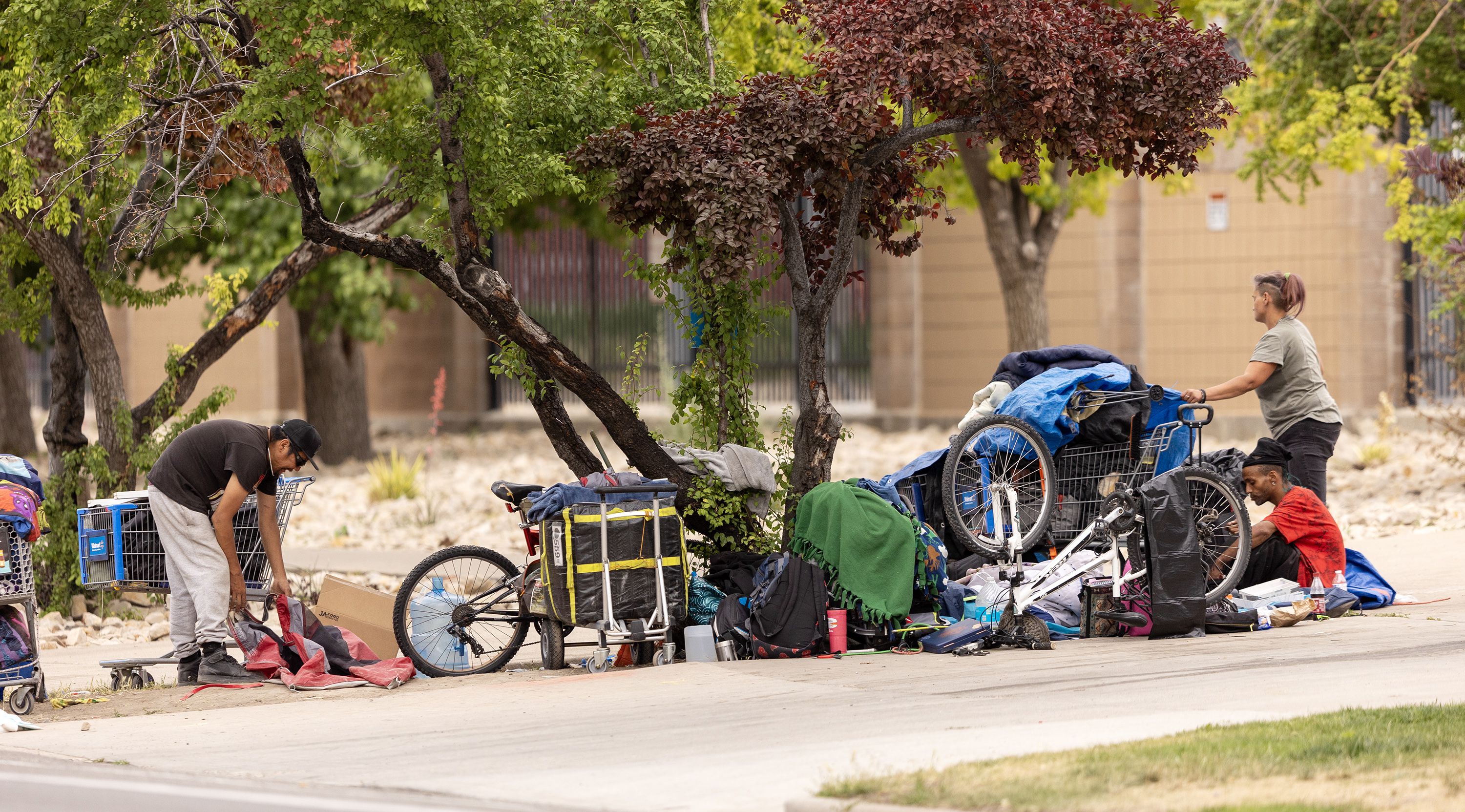 Homeless people sit or walk around small campsites in Salt Lake City on Wednesday. As total numbers of people experiencing homelessness slightly increased from a year ago, Utah is making headway in developing deeply affordable housing, according to a new state report on homelessness.