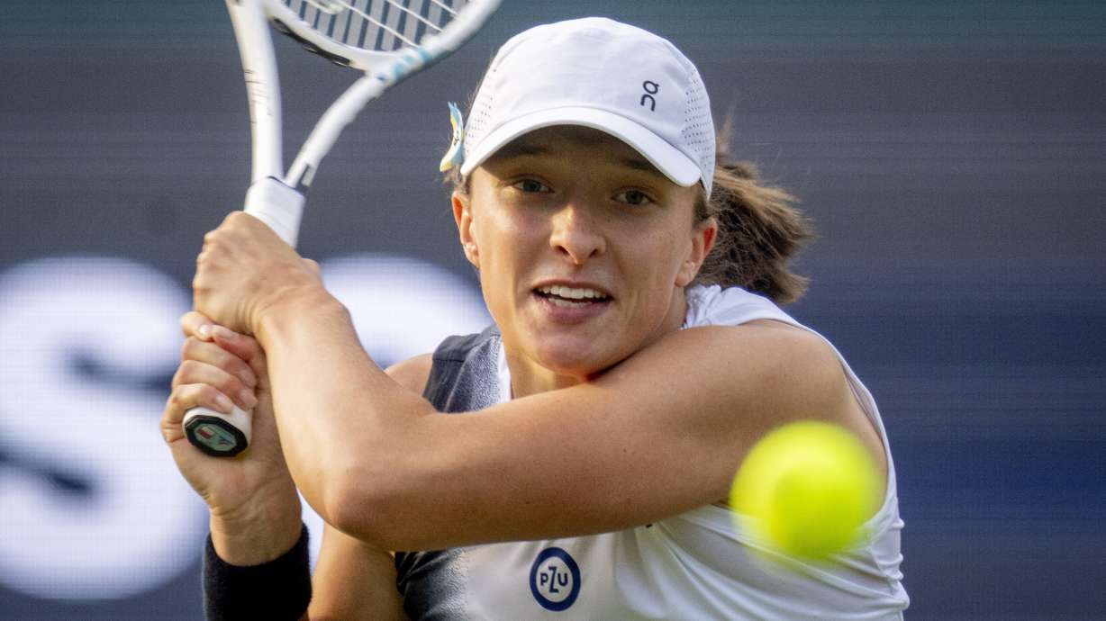 FILE - Poland's Iga Swiatek hits a backhand to Tatjana Maria, of Germany, during their first round WTA tour tennis match in Bad Homburg, Germany, Monday, June 26, 2023. Swiatek is expected to compete at Wimbledon next week.