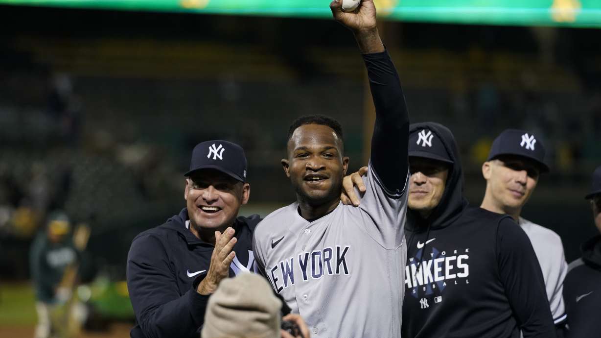 New York Yankees' Domingo Germán, center, celebrates after pitching a perfect game against the Oakland Athletics during a baseball game in Oakland, Calif., Wednesday, June 28, 2023. The Yankees won 11-0.