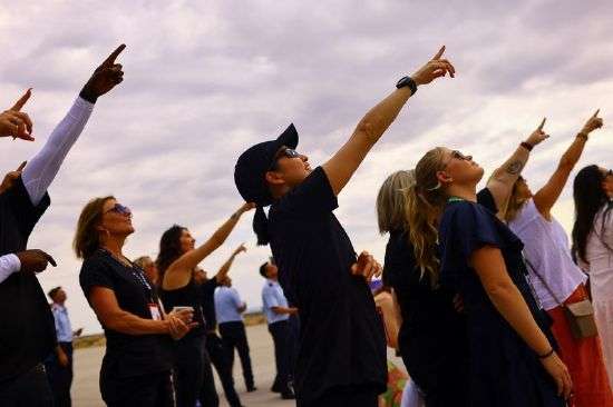 People watch the return of the rocket to the spaceport on the day of Virgin Galactic's rocket plane first commercial flight to the edge of space, at the Spaceport America facility, in Truth or Consequences, New Mexico, Wednesday.