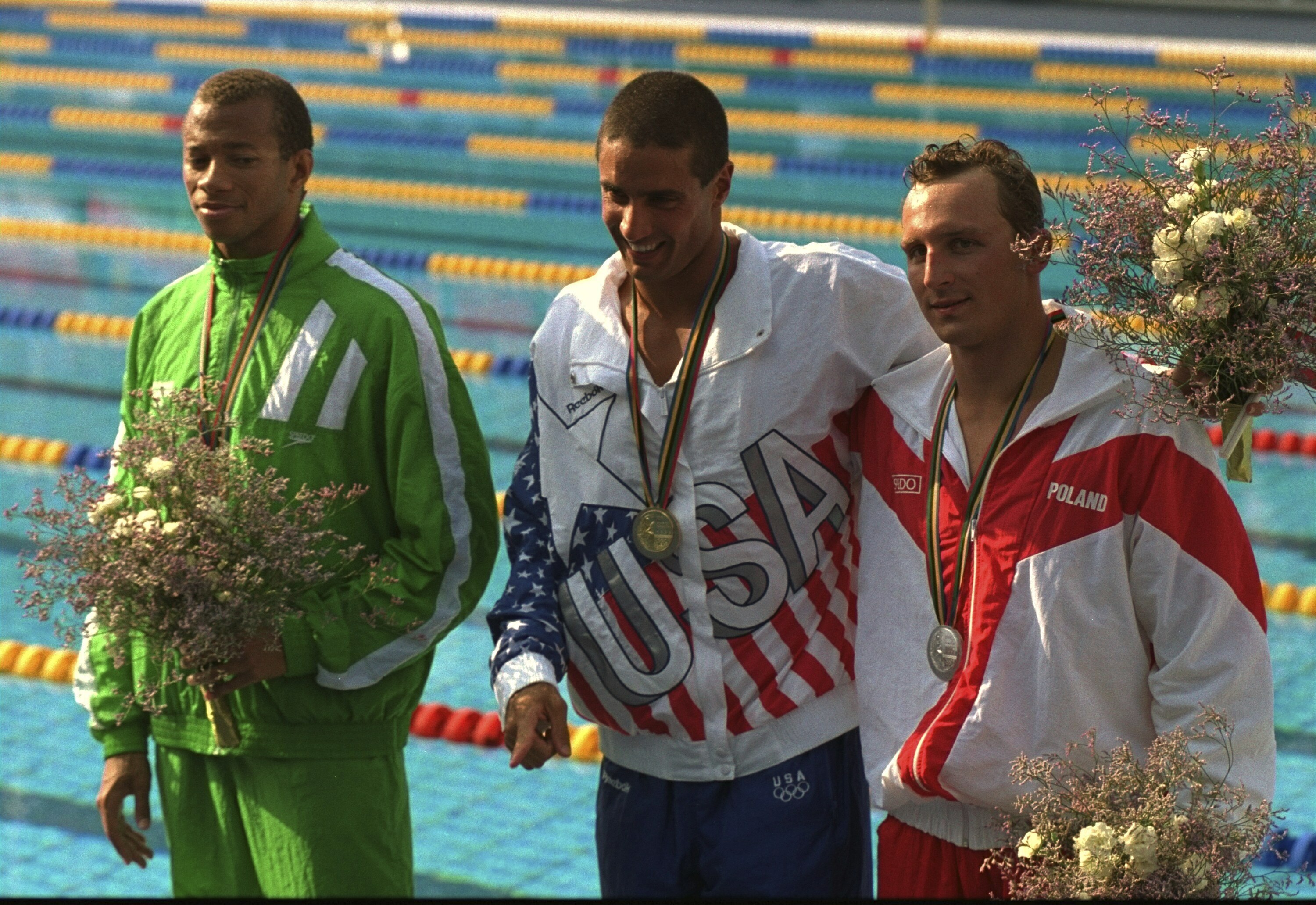 FILE - Pablo Morales, center, from the UnitesStates, displays the gold medal he won in the Olympic men's 100-meter butterfly in Barcelona, July 27, 1992. Morales is flanked by runners-up Rafal Szukala, right, from Poland, who took the silver medal, and Anthony Nesty, left, from Suriname, who won the bronze. In a sport still struggling to diversify, Nesty is a significant presence on the pool deck at the U.S. national championships. 