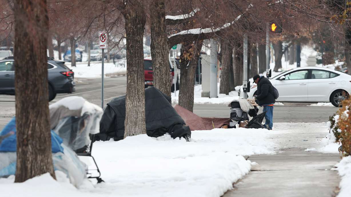 A man stands at one of three homeless tent camps in Salt Lake City on Dec. 20, 2022. The Utah Homelessness Council on Friday approved $3 million for a new emergency shelter for families.