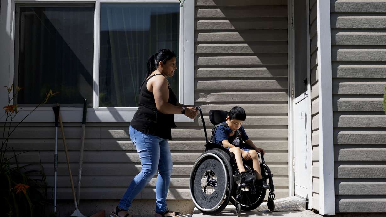 Cecilia Castillo maneuvers Junior’s wheelchair over two small ramps at their apartment in Salt Lake City on Friday. Tenants of the Housing Assistance Management Enterprise apartments accuse the Housing Authority of Salt Lake City of unfair rent hikes.