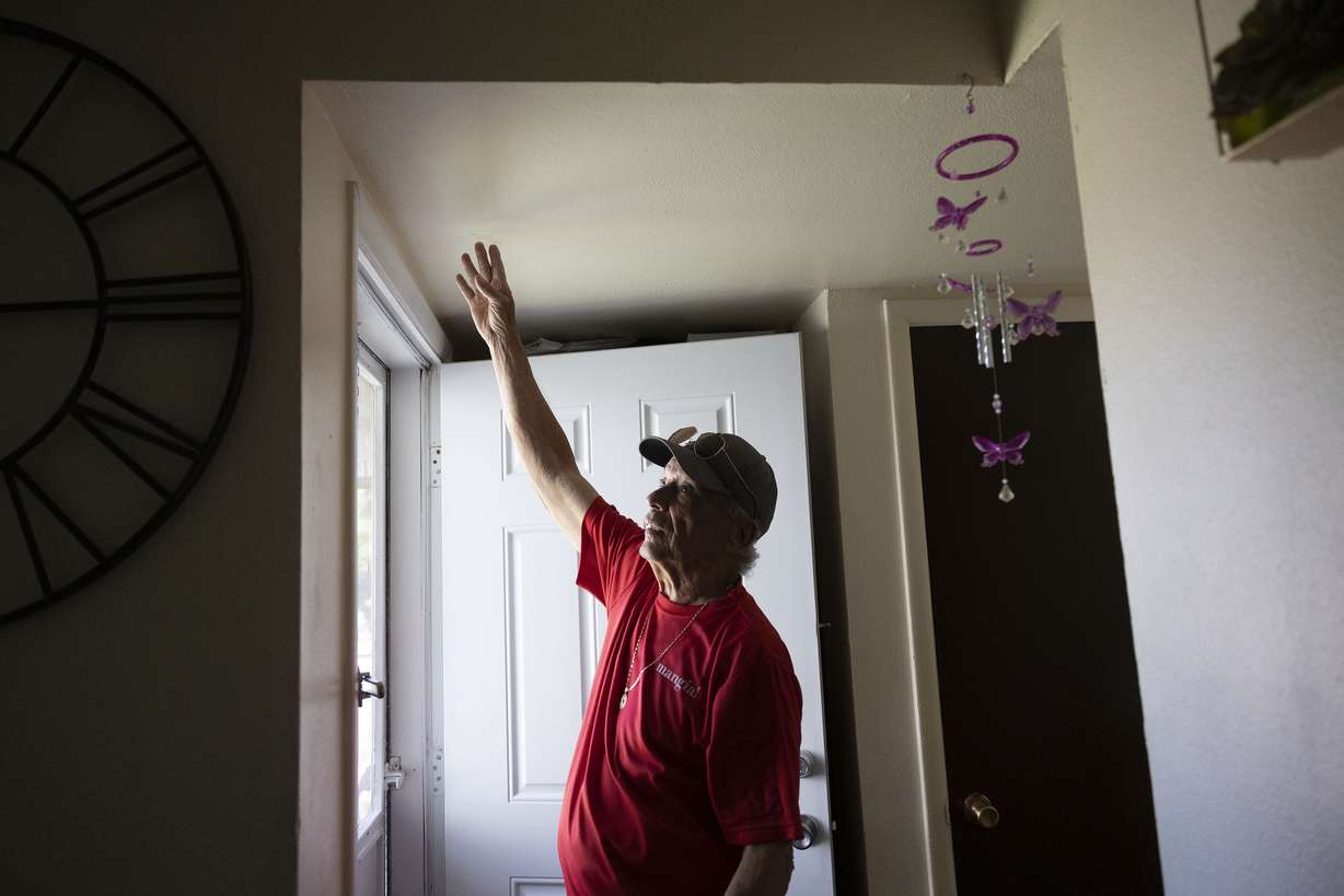 Lorenzo Rodriguez points out the ceiling cracks, new front door and insulation that he says he paid for and repaired himself at his apartment in Salt Lake City on Friday.