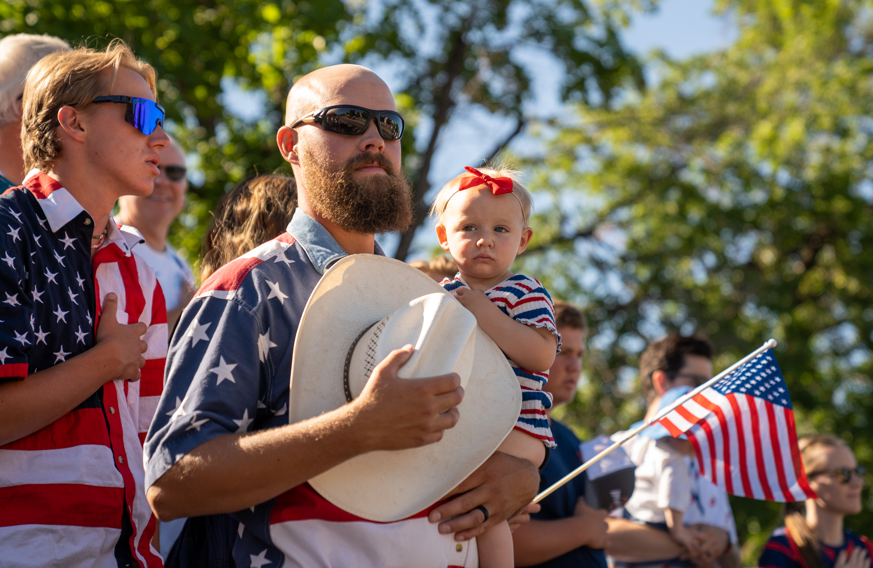 Kody Roney holds his daughter, Lanie, 1, as they pay respects during the America's Freedom Festival Grand Parade in Provo on July 4, 2022.