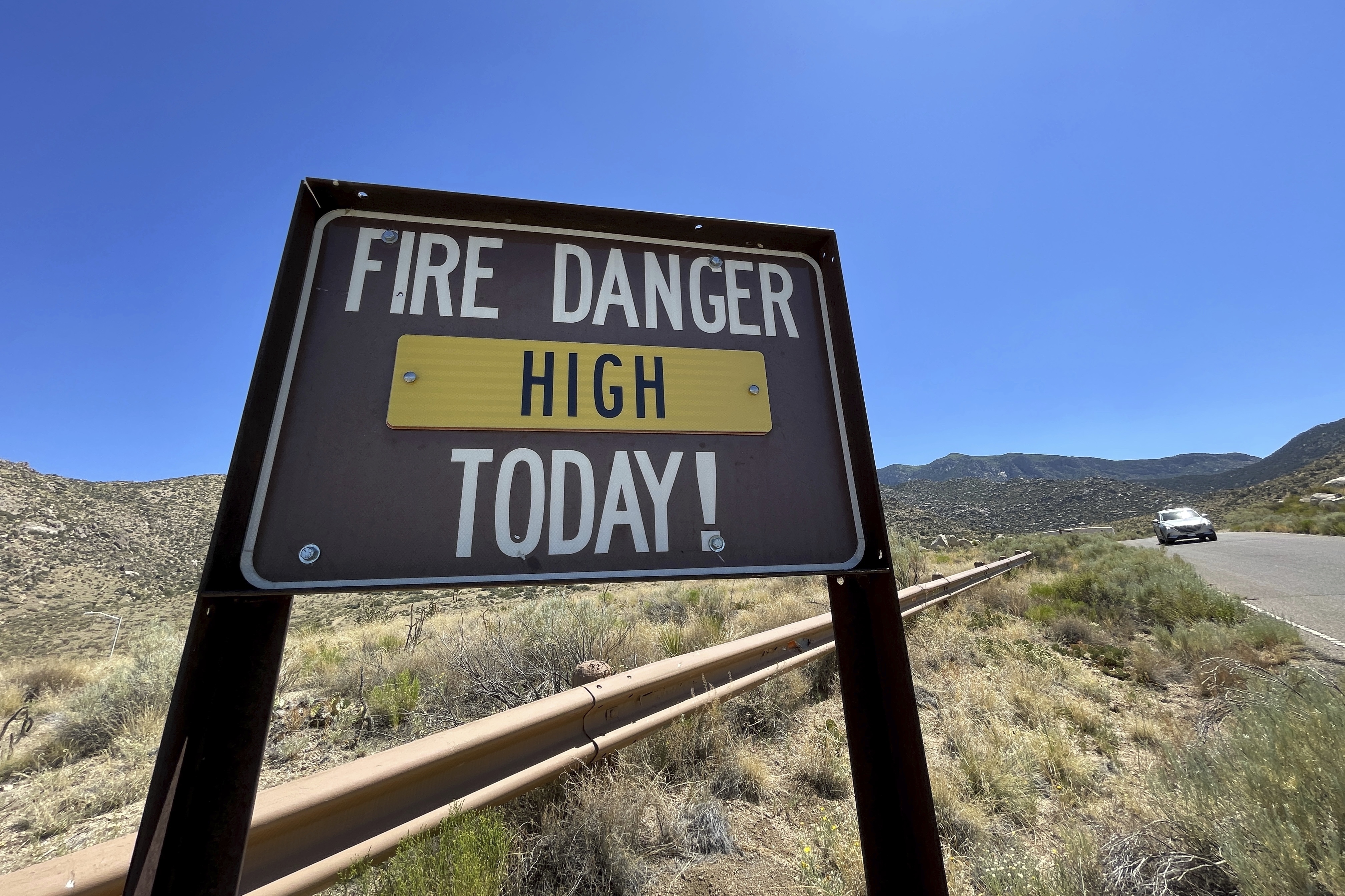 A sign warns of fire danger near Albuquerque, N.M., on Friday. U.S. Forest Service managers are urging people to use glow sticks and cans of party string as alternatives to fireworks, but some say the string should not be used out in nature.