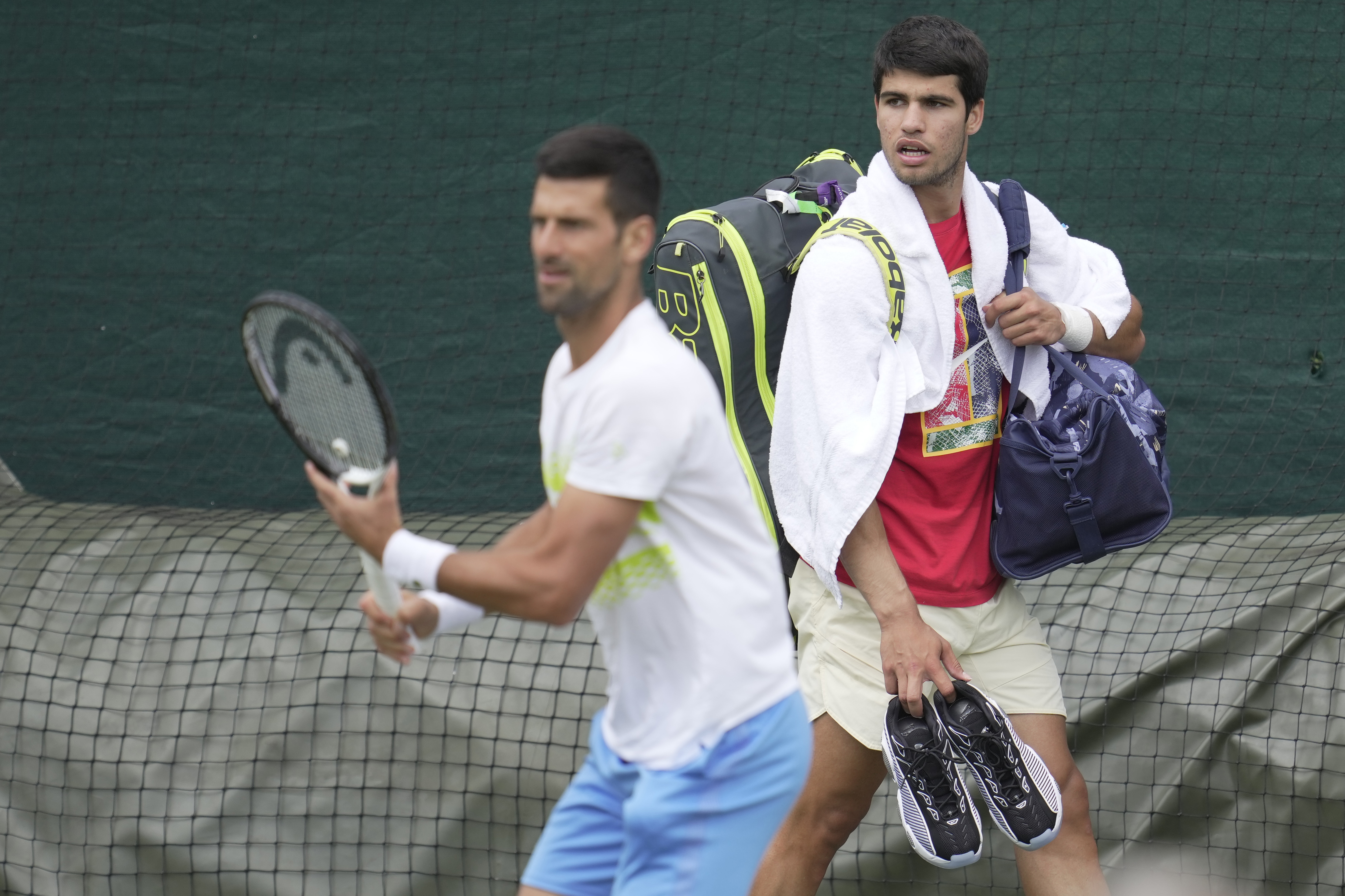 Novak Djokovic of Serbia, left and Carlos Alcaraz of Spain take part in a practice session ahead of the Wimbledon tennis championships at Wimbledon, in London, Sunday, July 2, 2023. The Wimbledon Tennis championships start on July 3. 
