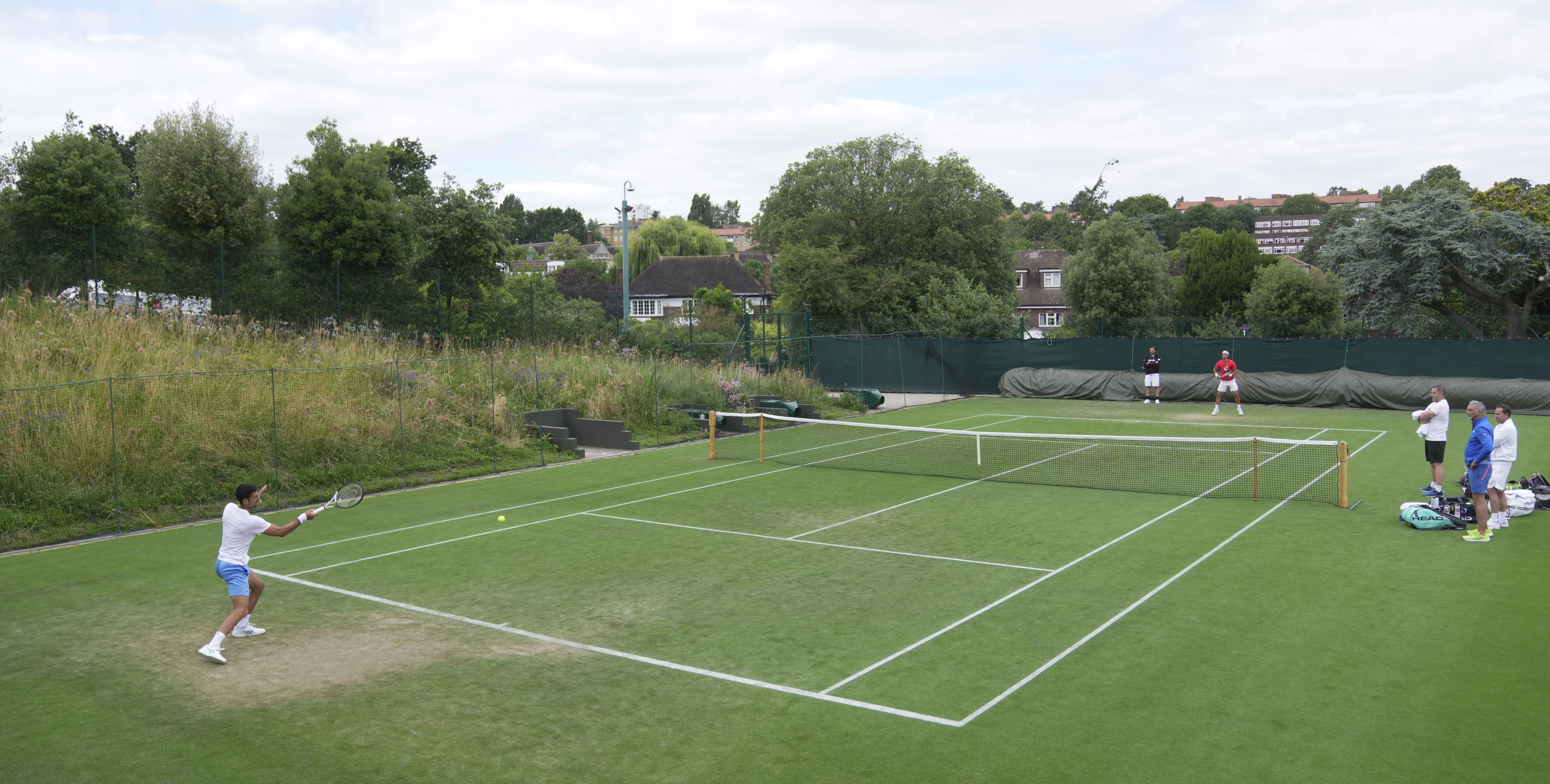 Novak Djokovic of Serbia, left, takes part in a practice session ahead of the Wimbledon tennis championships at Wimbledon, in London, Sunday, July 2, 2023. The Wimbledon Tennis championships start on July 3. 
