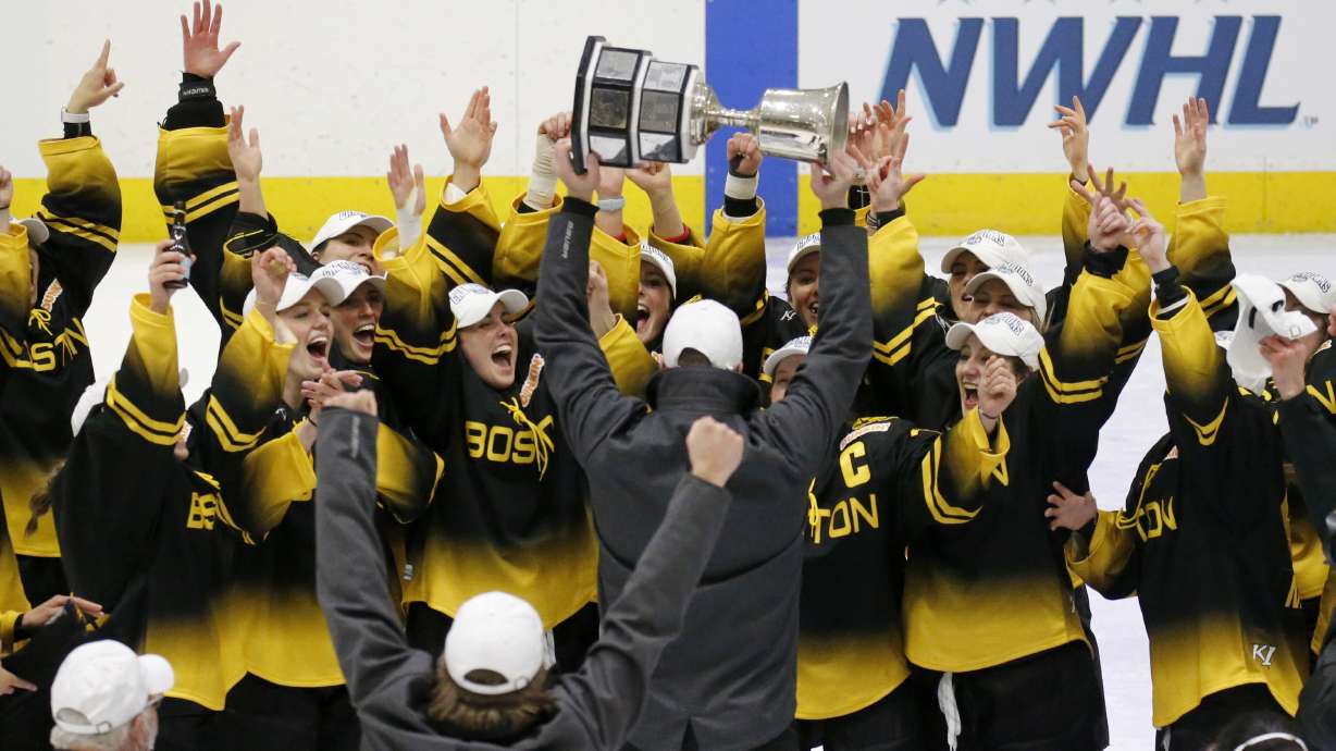 FILE - Boston Pride players cheer as coach Paul Mara hoists the NWHL Isobel Cup trophy after the team's win over the Minnesota Whitecaps in the championship hockey game in Boston, Saturday, March 27, 2021. Organizers announced plans Friday, June 30, 2023, to launch a new women’s professional hockey league in January that they hope will provide a stable, economically sustainable home for the sport's top players for years to come. The agreement ends a long standoff between the seven-team Professional Hockey Federation (PHF) and the PWHPA.