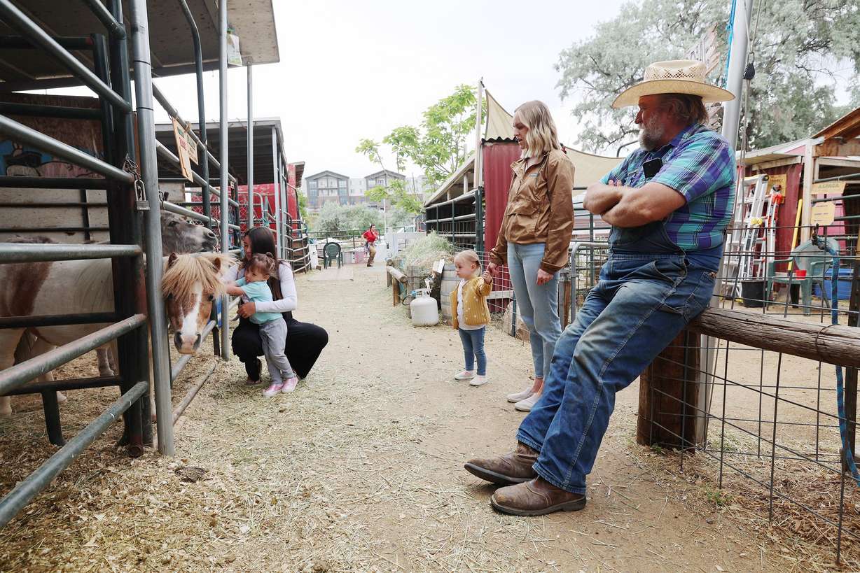 Gil Ma, the director of the farm at Gardner Village in West Jordan, talks with Kalli Pendley as she and her daughter Ellie Pendley and their friends Marisa Taylor and her daughter Frankie Taylor visit the farm on June 20.