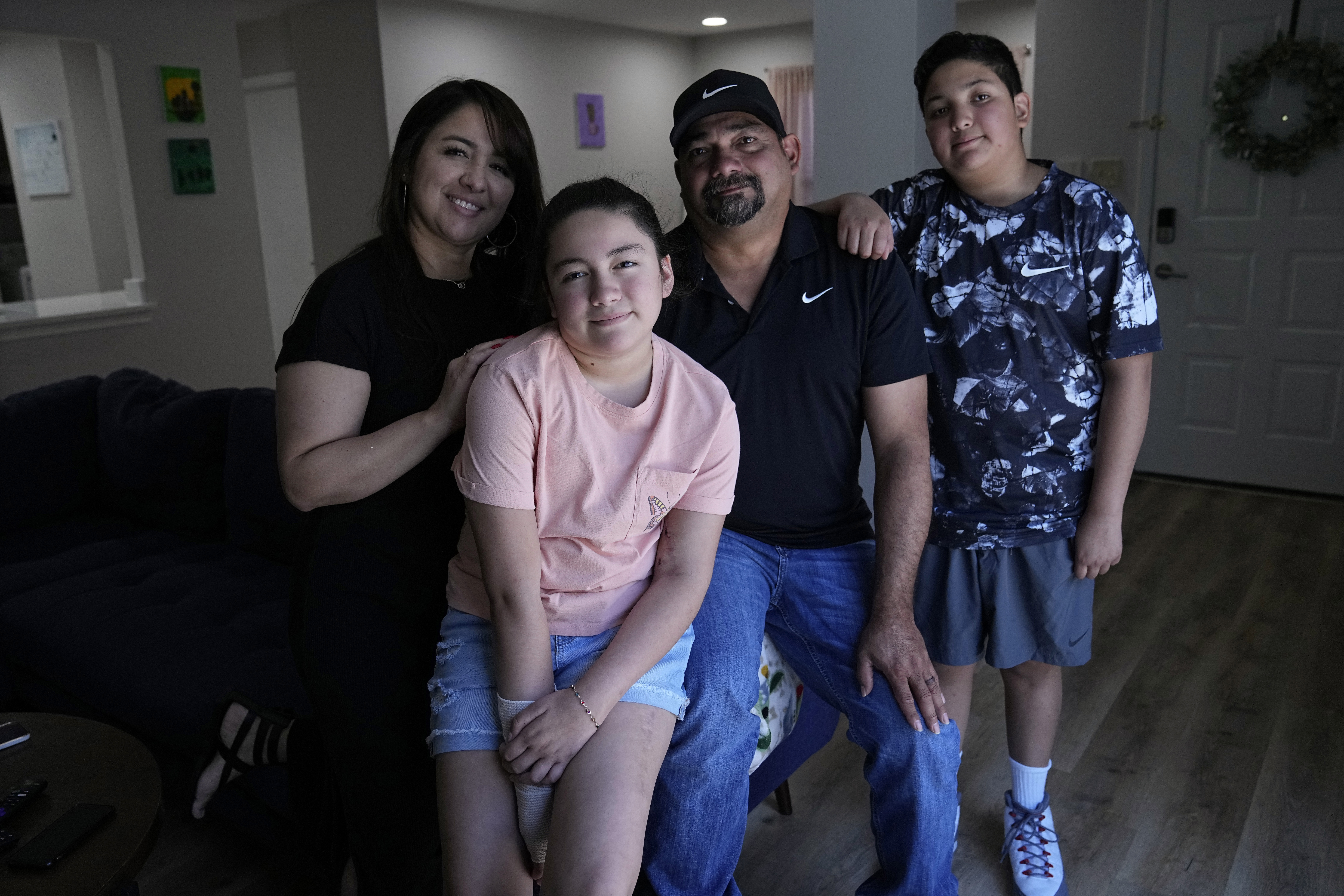 Mayah Zamora, second from left, a survivor of the mass shooting at Robb Elementary in Uvalde, Texas, poses for a photo with her mom Christina, left, dad Ruben, and brother Zach, right, at their home in San Antonio, June 27. 